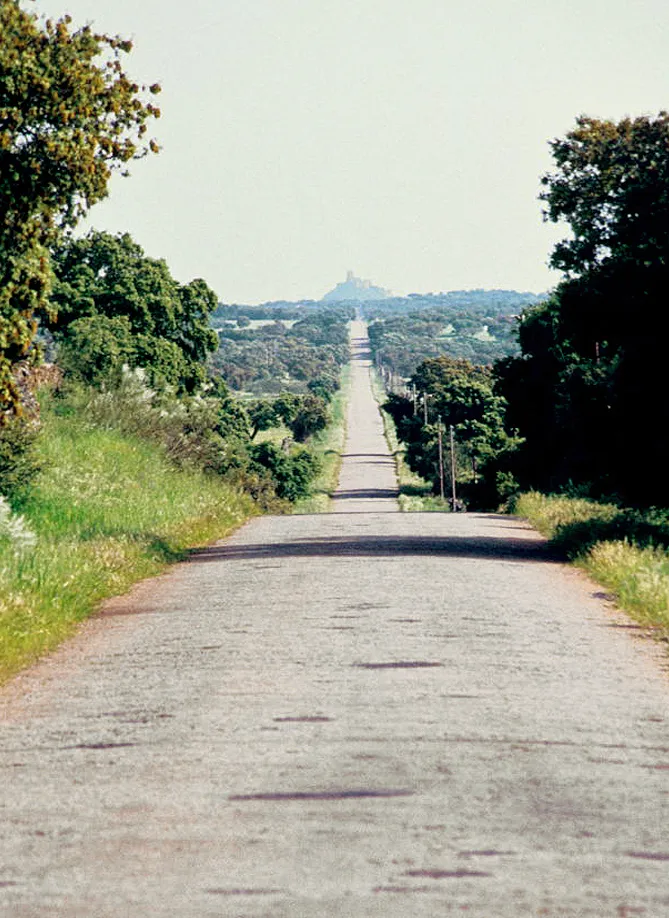 Photo showing: A road [nowadays EX-107]; in the background, hill and castle of Alconchel, Badajoz, Extremadura, Spain