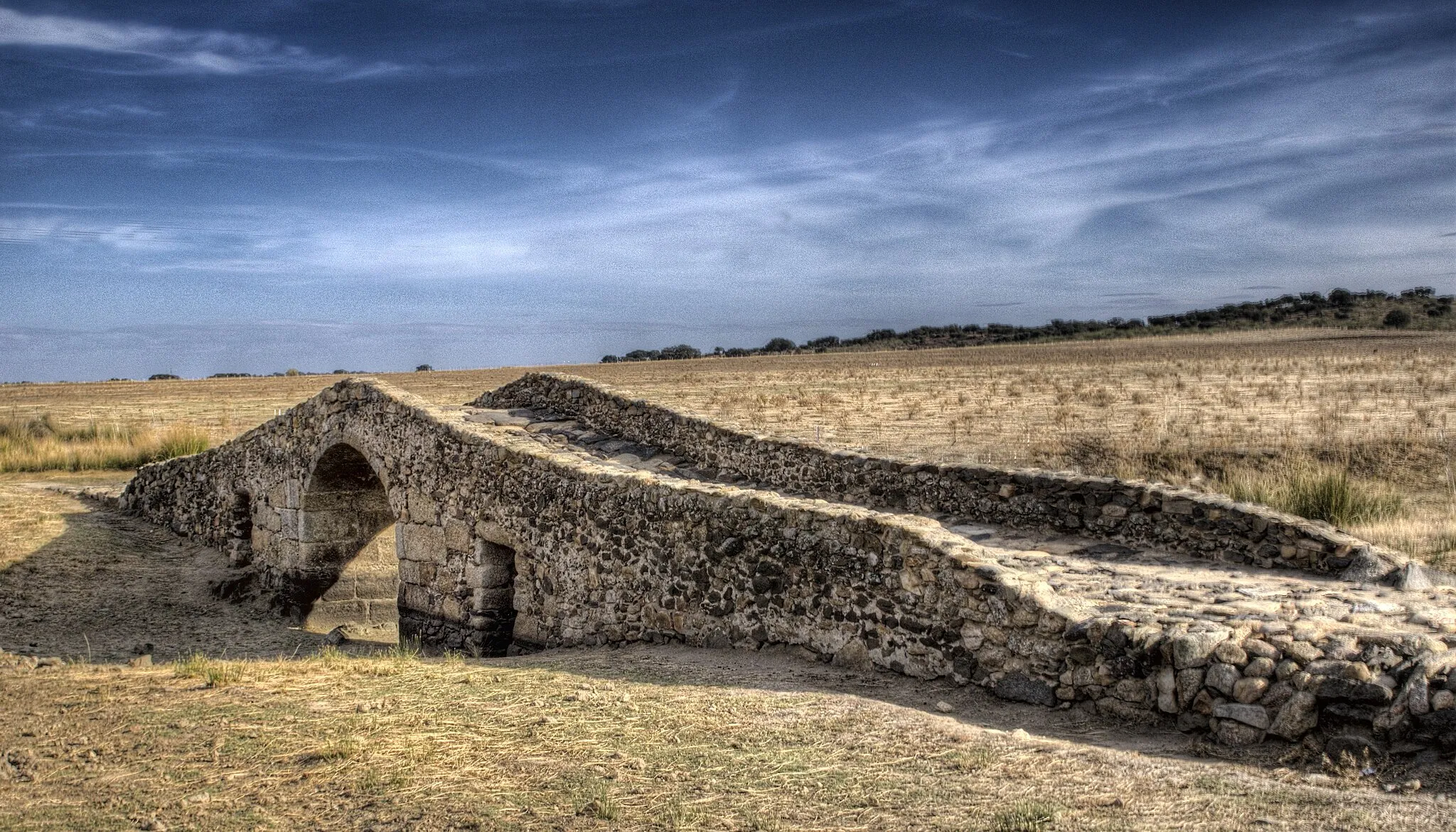 Photo showing: En el término municipal de la ciudad española de Cáceres, cerca de Aldea del Cano, un puente de origen romano permite cruzar el arroyo de Santiago a los peregrinos del Camino. Un poco antes se levanta un miliario, el hito kilométrico de las calzadas romanas. Una milla romana equivale a unos 1480 m.