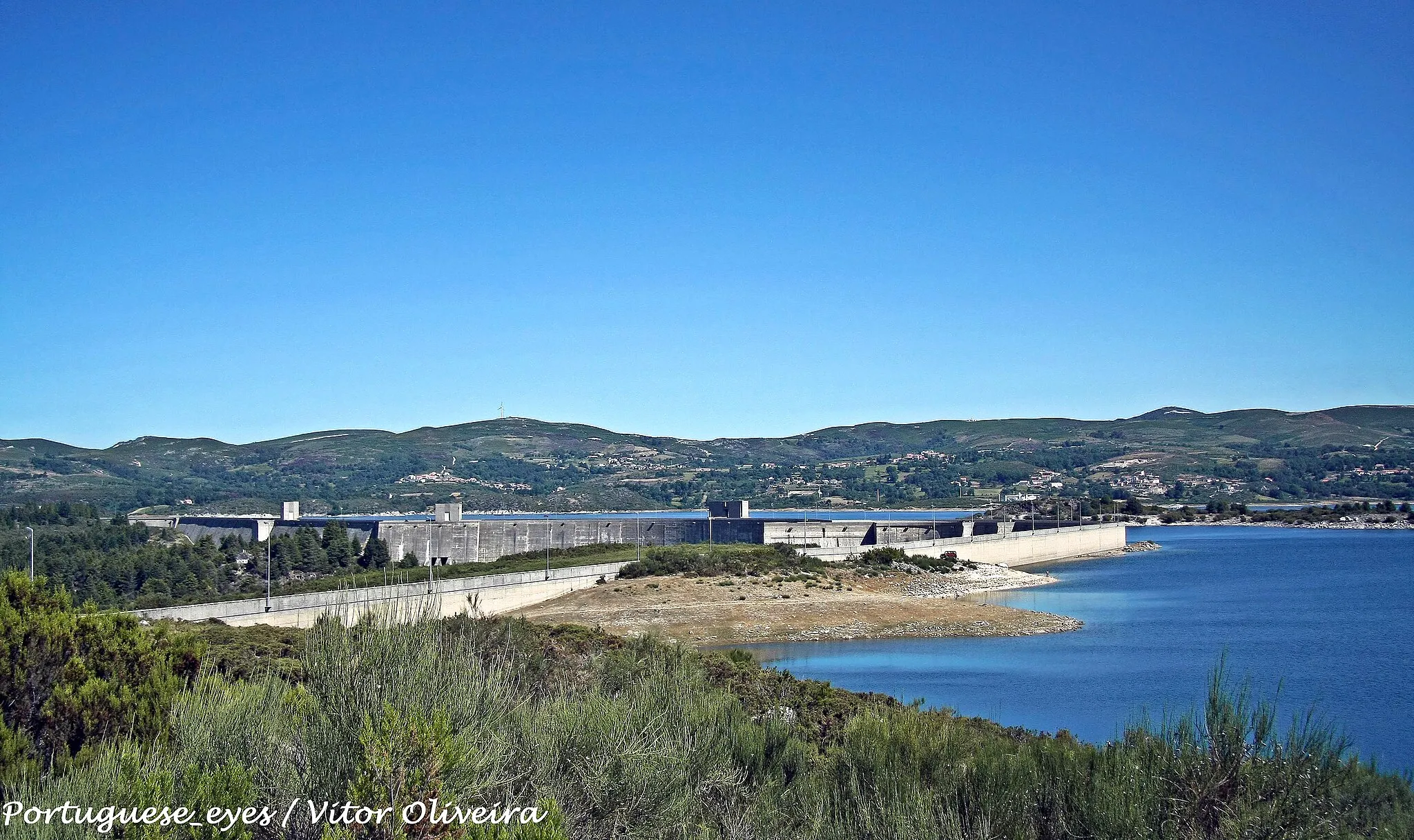 Photo showing: Também conhecida por Barragem dos Pisões, é a segunda maior barragem de Portugal, a seguir à de Alqueva. É alimentada pelo rio Rabagão, foi concluída em 1964, têm uma altura de 94m e um comprimento de coroamento de 1.897 metros, tem uma capacidade de descarga máxima de 500 m³/s.
A sua albufeira possui uma área de cerca de 2.200 hectares e uma capacidade de 569 hm3, com um volume morto (não utilizável) de 10,77 hm³.
www.portugal-imagens.blogspot.com/

See where this picture was taken. [?]