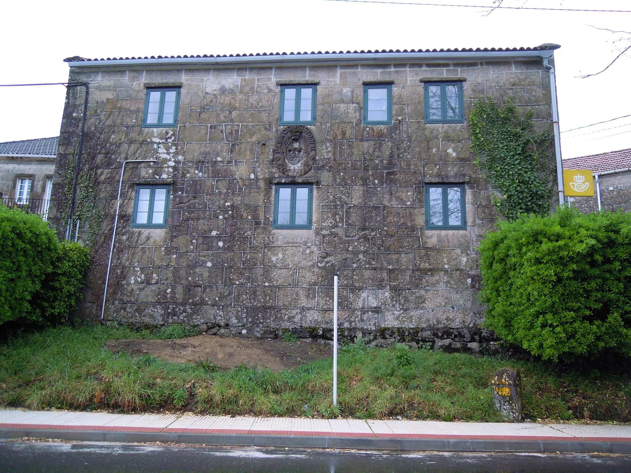 Photo showing: Antiga casa consistorial do Concello de Cotobade, na Chan (Carballedo, Cerdedo-Cotobade) actual edificio de Correos. Diante, Fito quilométrico 13 da estrada PO-233.