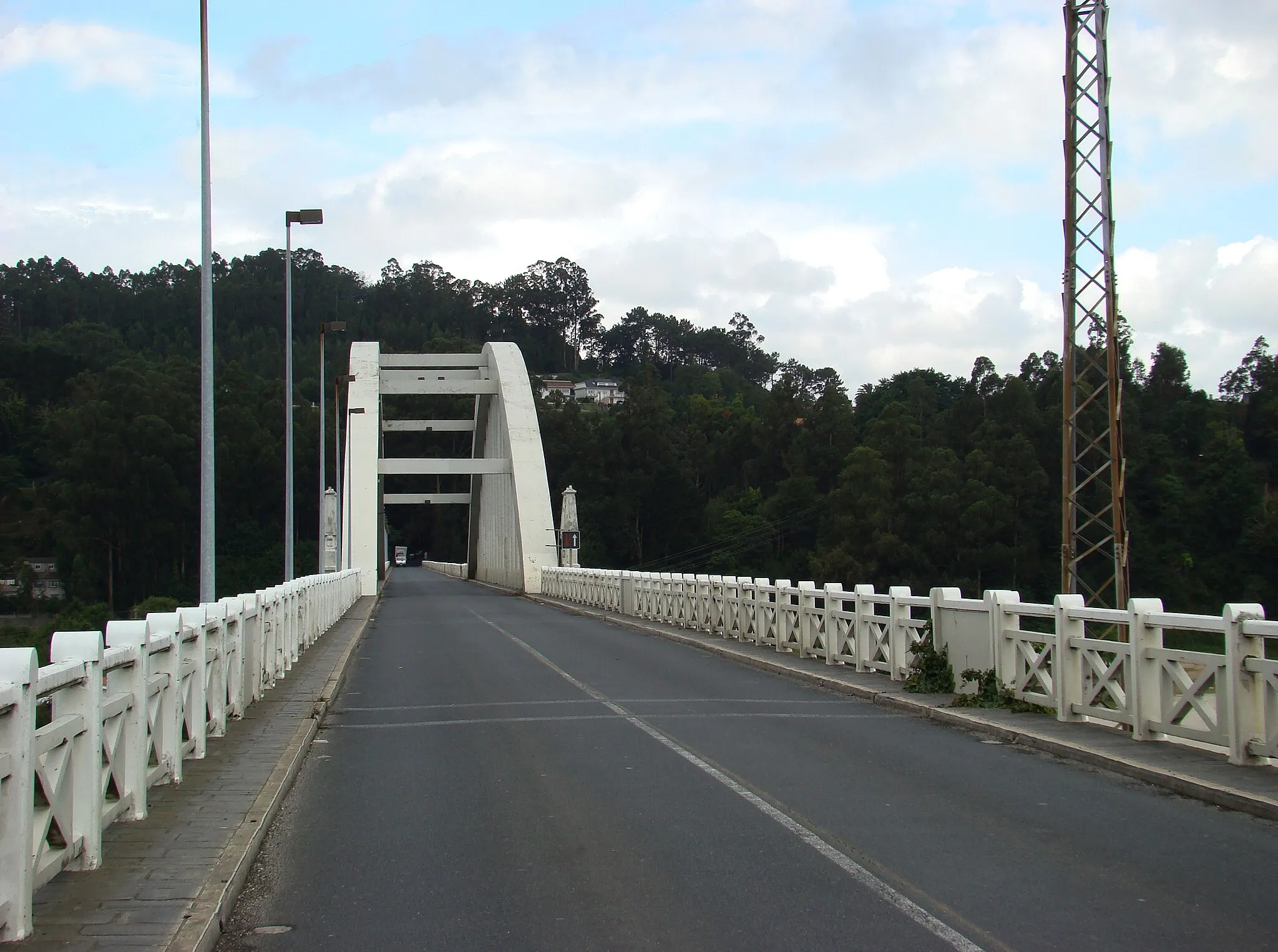 Photo showing: Vuela hasta este sitio / Fly to this location
(Precisa / requires Google Earth)
Ver en GoogleMaps / See in GoogleMaps
Puente construido en la bocana de la Ría de Betanzos, entre los años 1939 y 1942, por el prestigioso ingeniero Eduardo Torroja. El empleo de hormigón armado supuso una gran novedad en su momento, pues era la primera vez que se utilizaba este material por estas tierras para una obra de semejantes dimensiones. Lo más característico de este puente es un gran arco central que le confiere a la par delicadeza y majestuosidad. Desde el puente se contemplan espectaculares panorámicas de la ría; particularmente singulares son las nocturnas. turgalicia
Se trata del ingeniero Eduardo Torroja Miret, considerado según se lee en la wikipedia el máximo especialista mundial en su época en construcciones de hormigón. Su hijo José Antonio Torroja Cavanillas, también destacado ingeniero (Premio Nacional de Ingeniería Civil en 2007), es el padre de Ana Torroja (Mecano). Leo en wikipedia una frase del padre: "He pasado a ser el hijo de mi padre al padre de mi hija"
Eduardo Torroja Miret en wikipedia
José Antonio Torroja Cavanillas en wikipedia

Ana Torroja en wikipedia