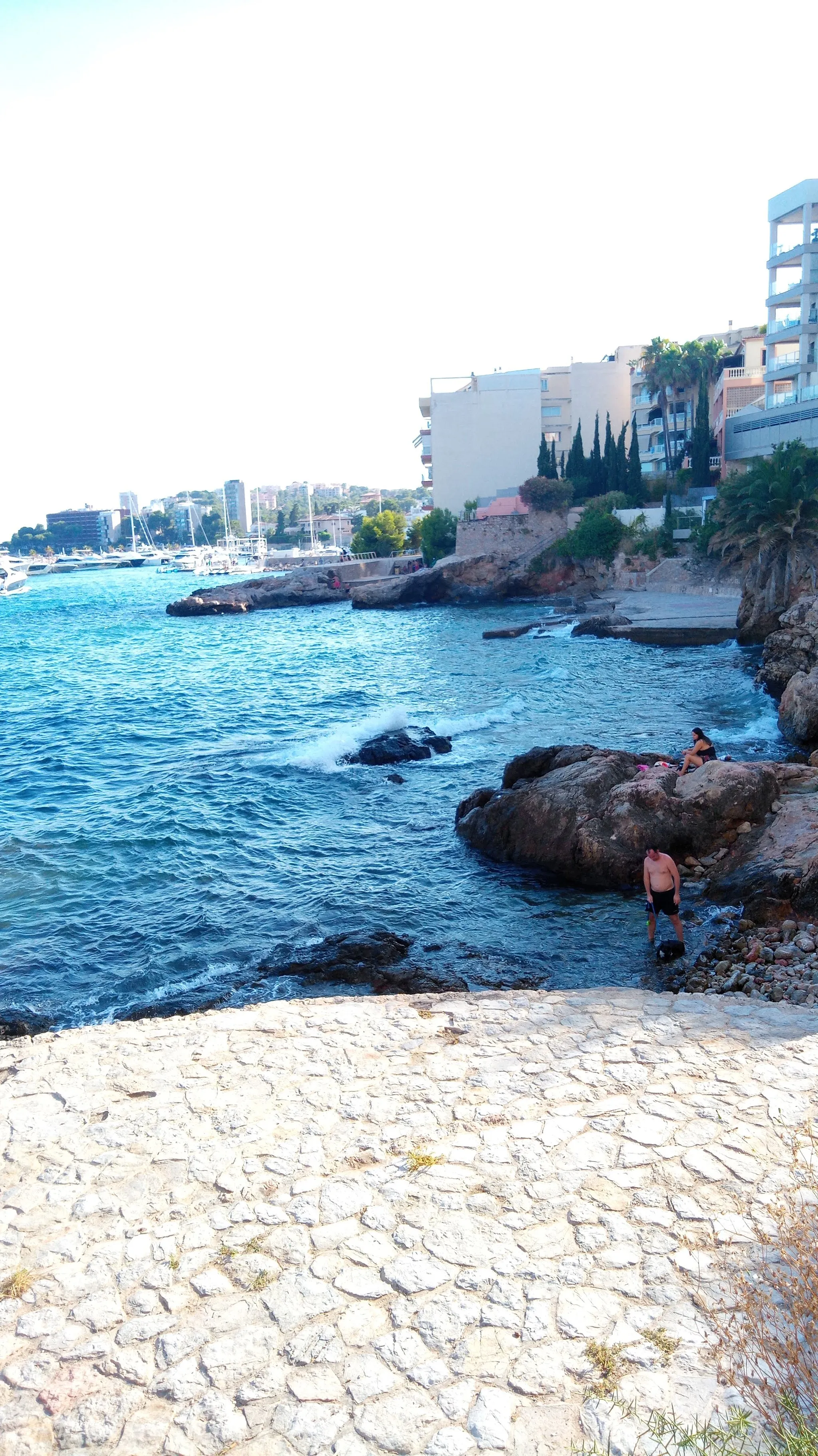 Photo showing: Cala Guix, al terme de Palma. Al fons, amagat entre les roques, hi ha un raconet d'arena.