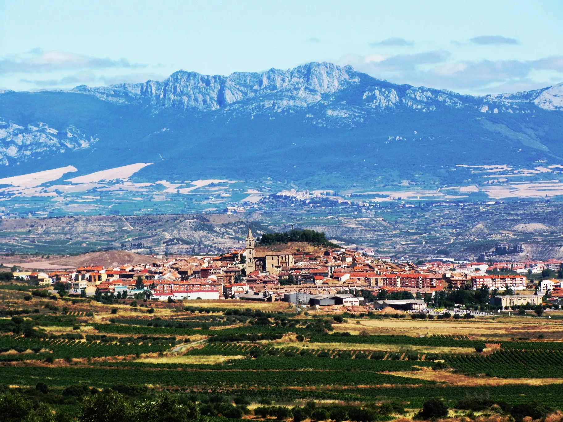 Photo showing: Navarrete visto desde el cerro de las bodegas de Medrano. Detrás se aprecia la localidad de Laguardia en lo alto de una colina. Como telón de fondo se alza la Sierra de Cantabria