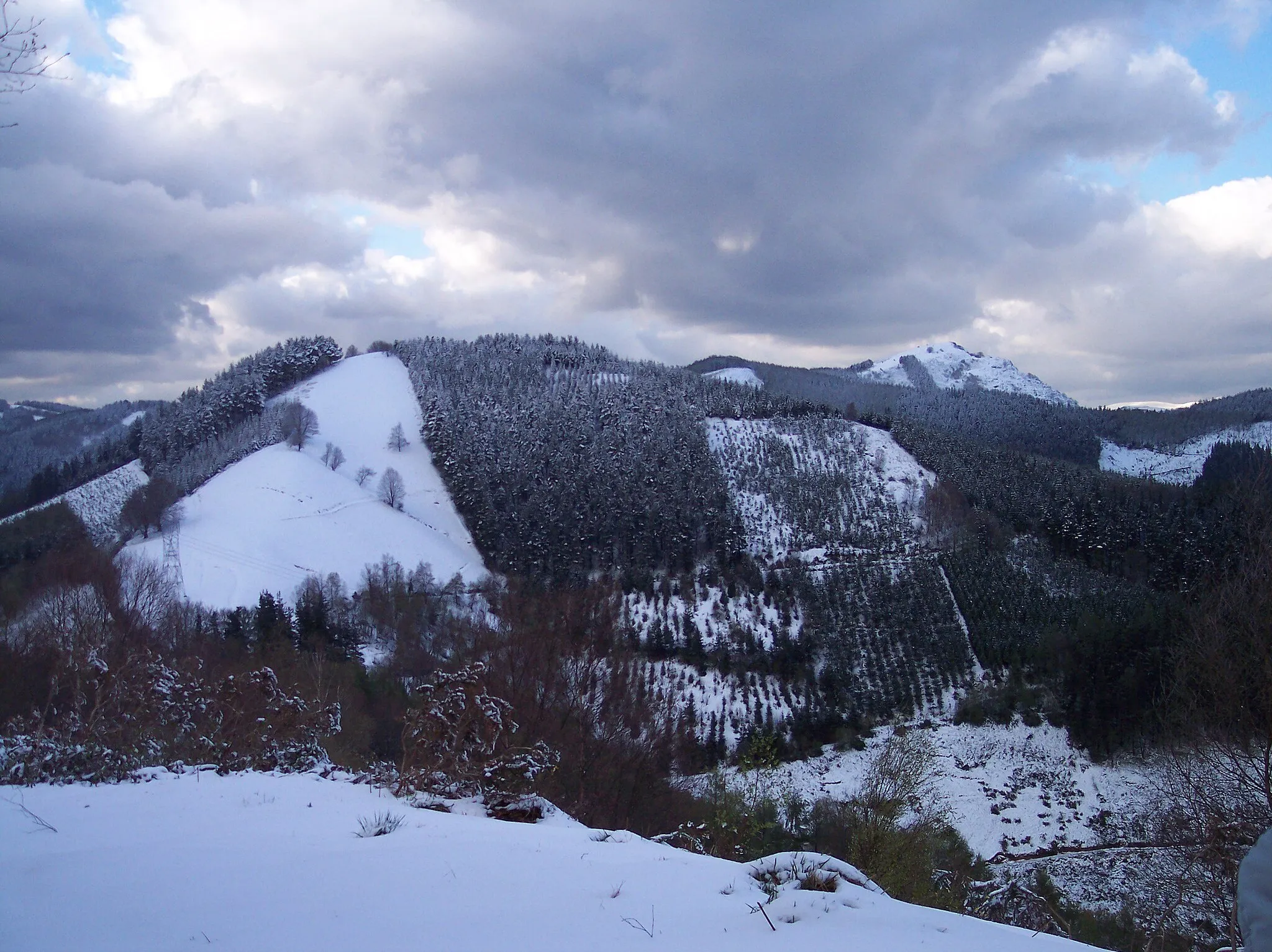 Photo showing: Zormendi, under the snow, viewed from mount Usurbe. The highest mountain, on the right-hand side, is Murumendi.