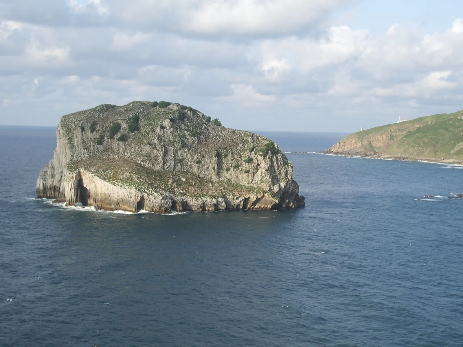 Photo showing: Aketx island from Gaztelugatxeko Doniene church, Biscay, Basque Country. On the background, the Cape of Matxitxako.