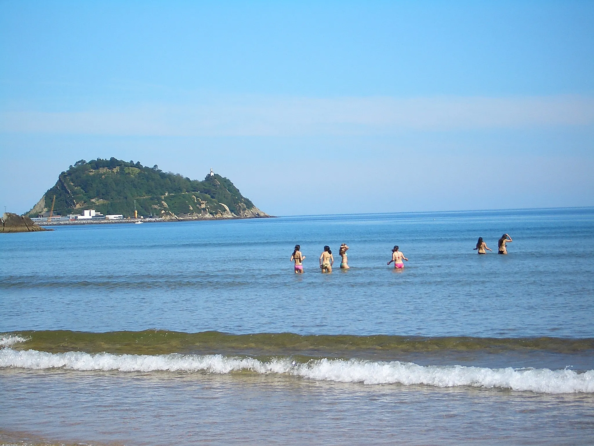 Photo showing: Beach-goers at the beach in Zarautz against the background of "el Raton" (the mouse-shaped peninsula at Getaria)