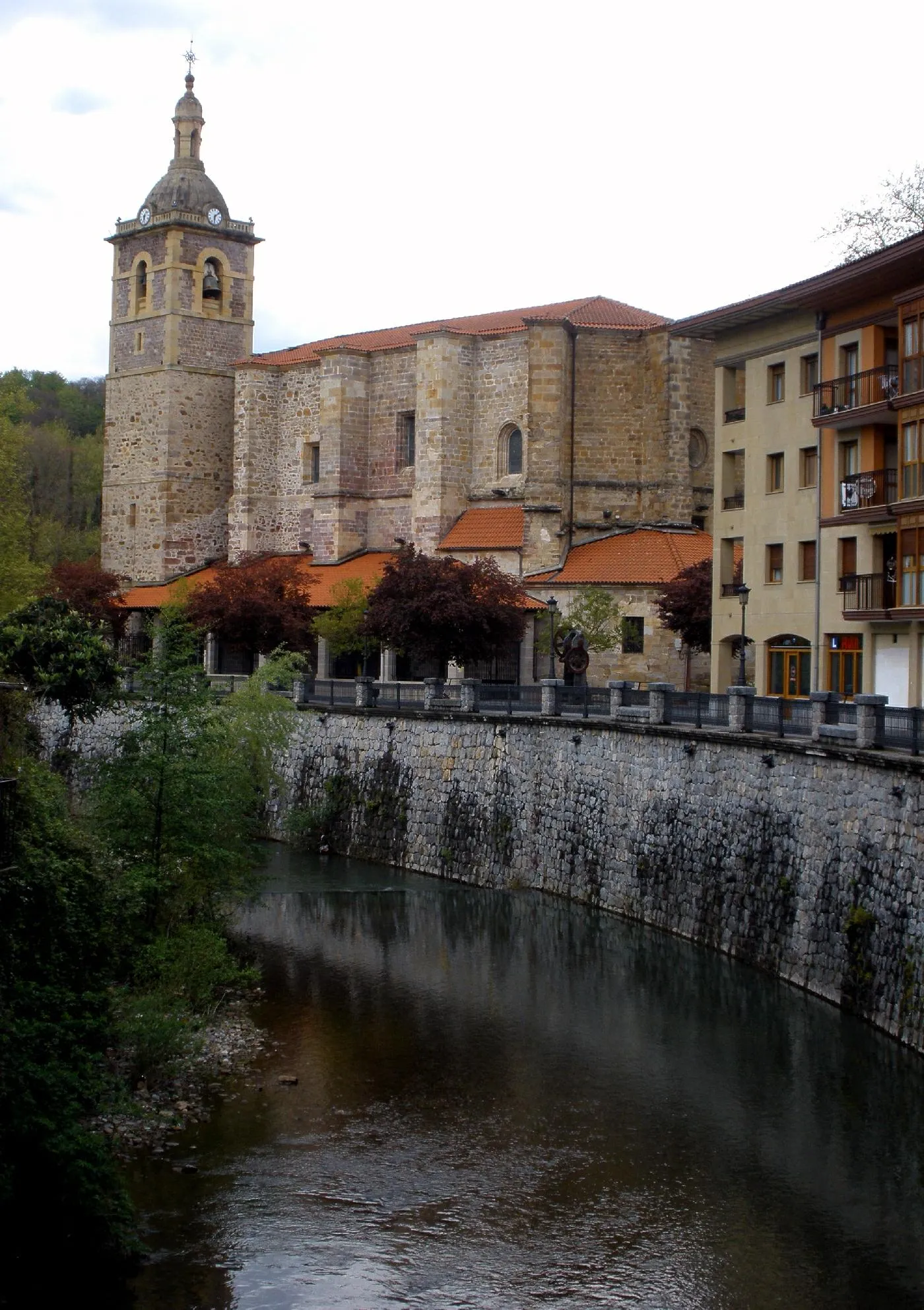 Photo showing: El río Agauntza, a su paso por el centro de Lazkao. Al fondo, la iglesia parroquial de San Miguel (Guipúzcoa, País Vasco, España)