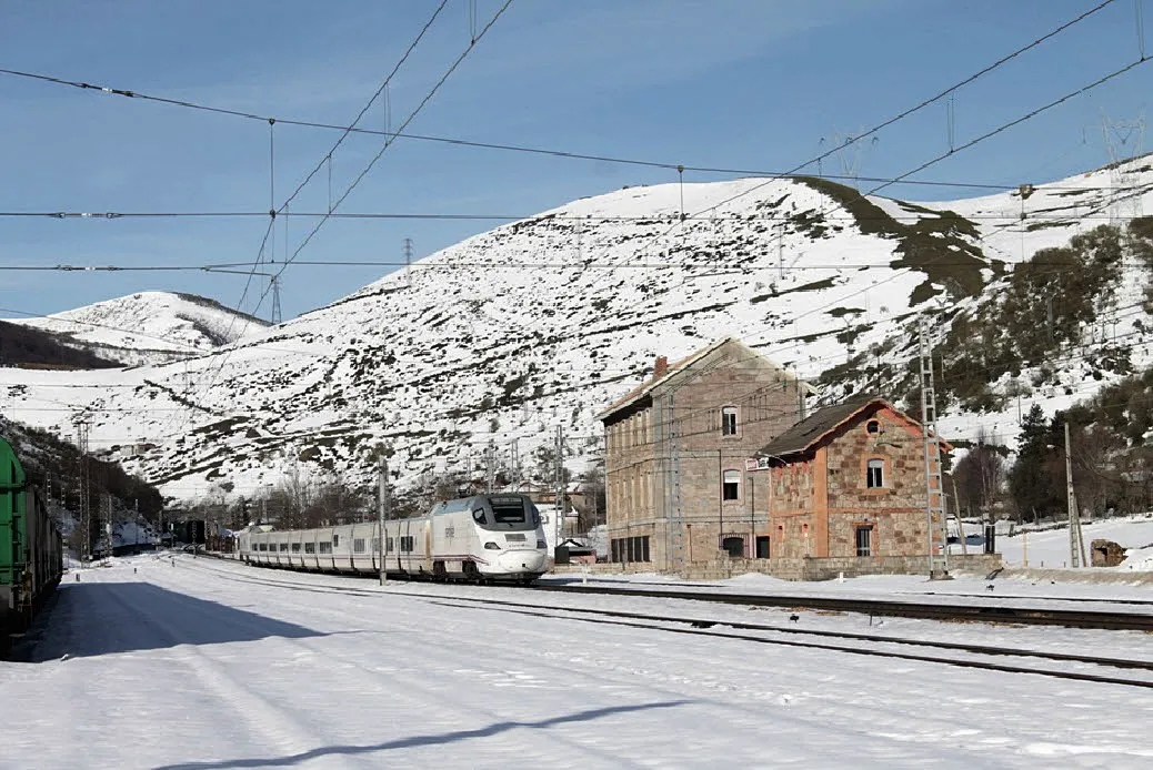 Photo showing: At last the snow arrived at the Pajares Pass route in 2016. Here we can see the passage of an ALVIA S-130 train through the Busdongo station. Once the Pajares Base Tunnel is in service, this line will be closed.