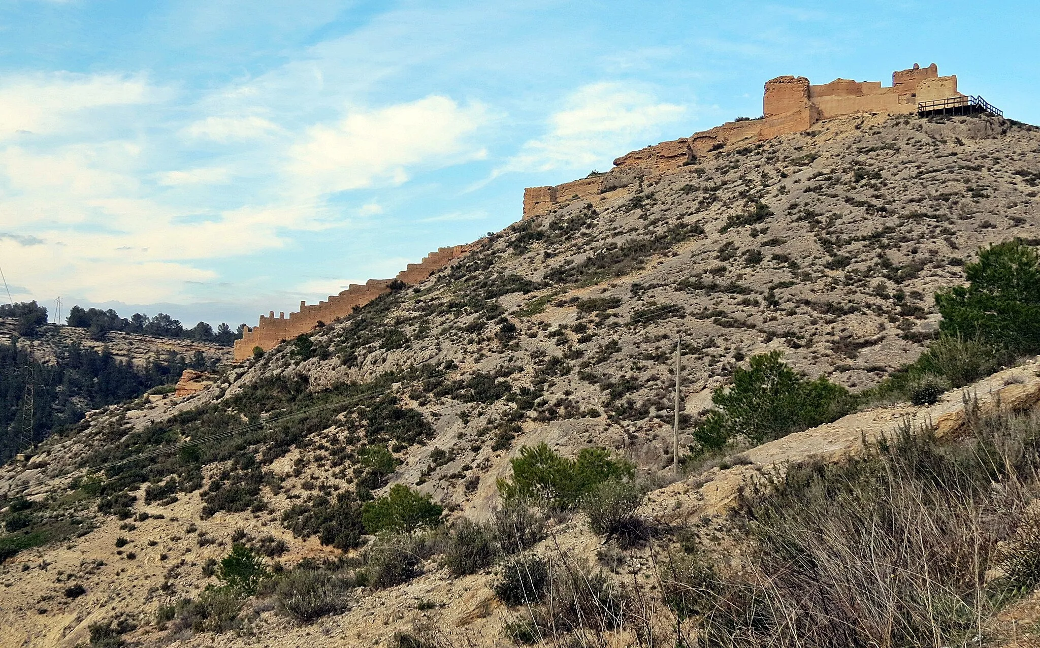 Photo showing: The fortress of Pliego is located in a strategic place since dominating the current population, the old fortified town of La Mota, also known as Castle of the Paleras, and the water channel of the river Pliego. It's an impressive element of control of the territory. But its origins don't seem very clear. Some authors date its construction from the 12th century, and claim that its construction in the Islamic period responds to the intention to give shelter to the inhabitants of La Mota. However, is the possibility of a later building, already in Christian times and under the lordly domain of the order of Santiago.
Their State of conservation, relatively good and restored in some areas a few years ago, allows us to contemplate a fully constructed defensive work with an excellent mud mortar, with a few elements in which it's still possible to distinguish elevation complete with his footsteps of round and battlements. Pliego Castle is declared of Cultural interest by the second additional provision of law 16/1985 of 25 June on Spanish historical heritage.

http://www.regmurcia.com/servlet/s.Sl?sit=a,89,c,522,m,1075&r=CeAP-2048-C_440_DETALLE_CENTRO