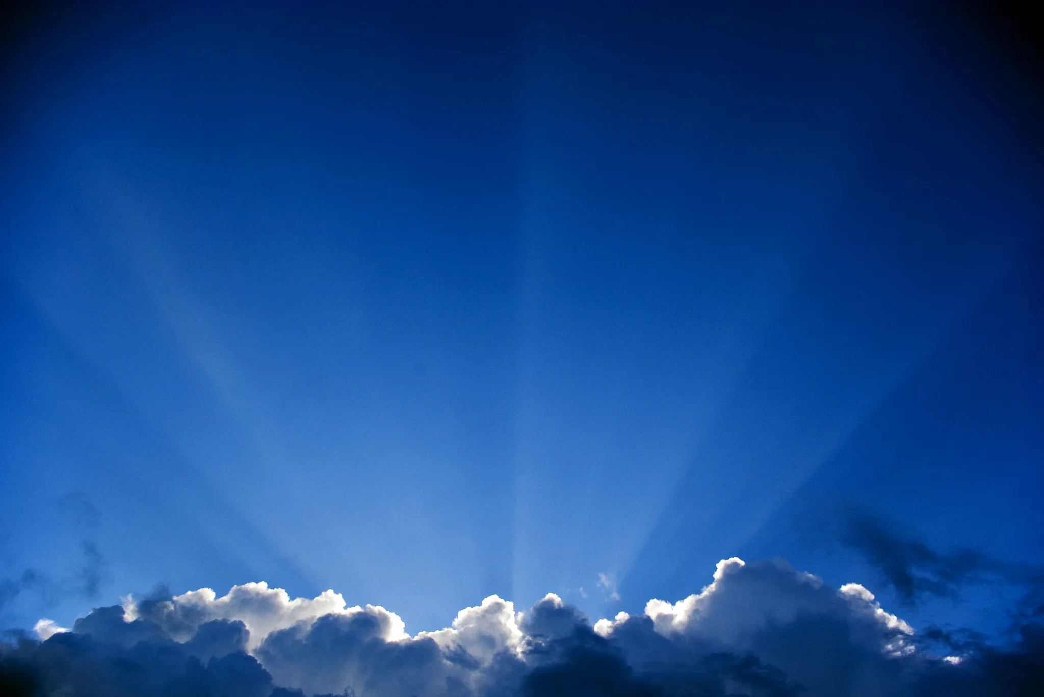 Photo showing: 500px provided description: The sun's rays shoot up from behind a cloud [#sky ,#rays ,#cloud ,#syn]