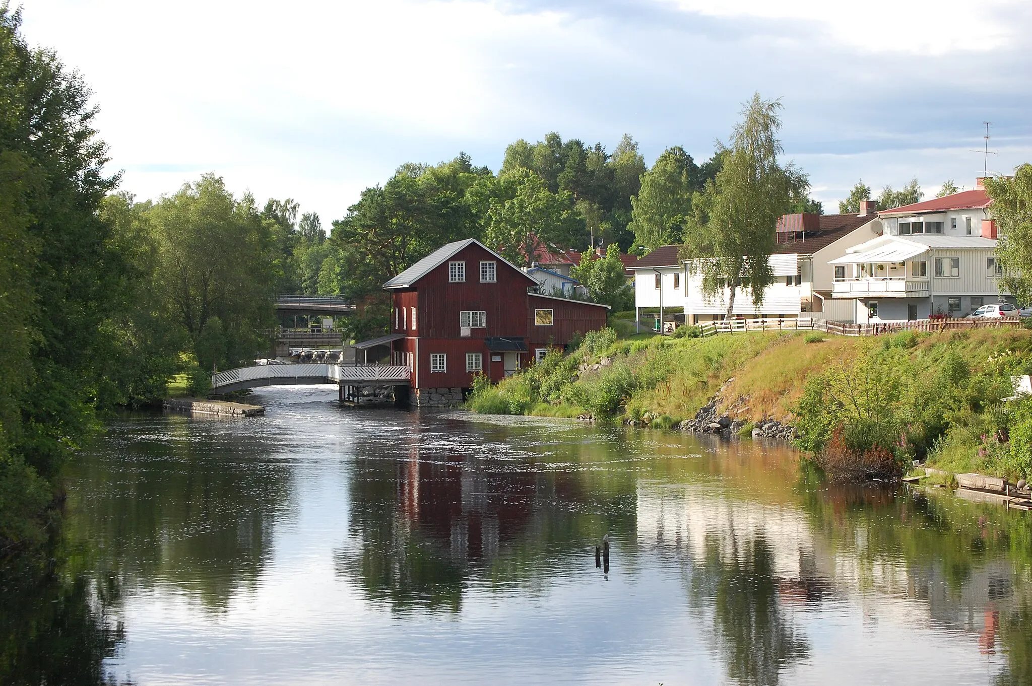 Photo showing: Dalslands kanal söder om den övre slussen i Töcksfors. Det röda huset är den gamla kvaren som har byggts om till pub och kafé.