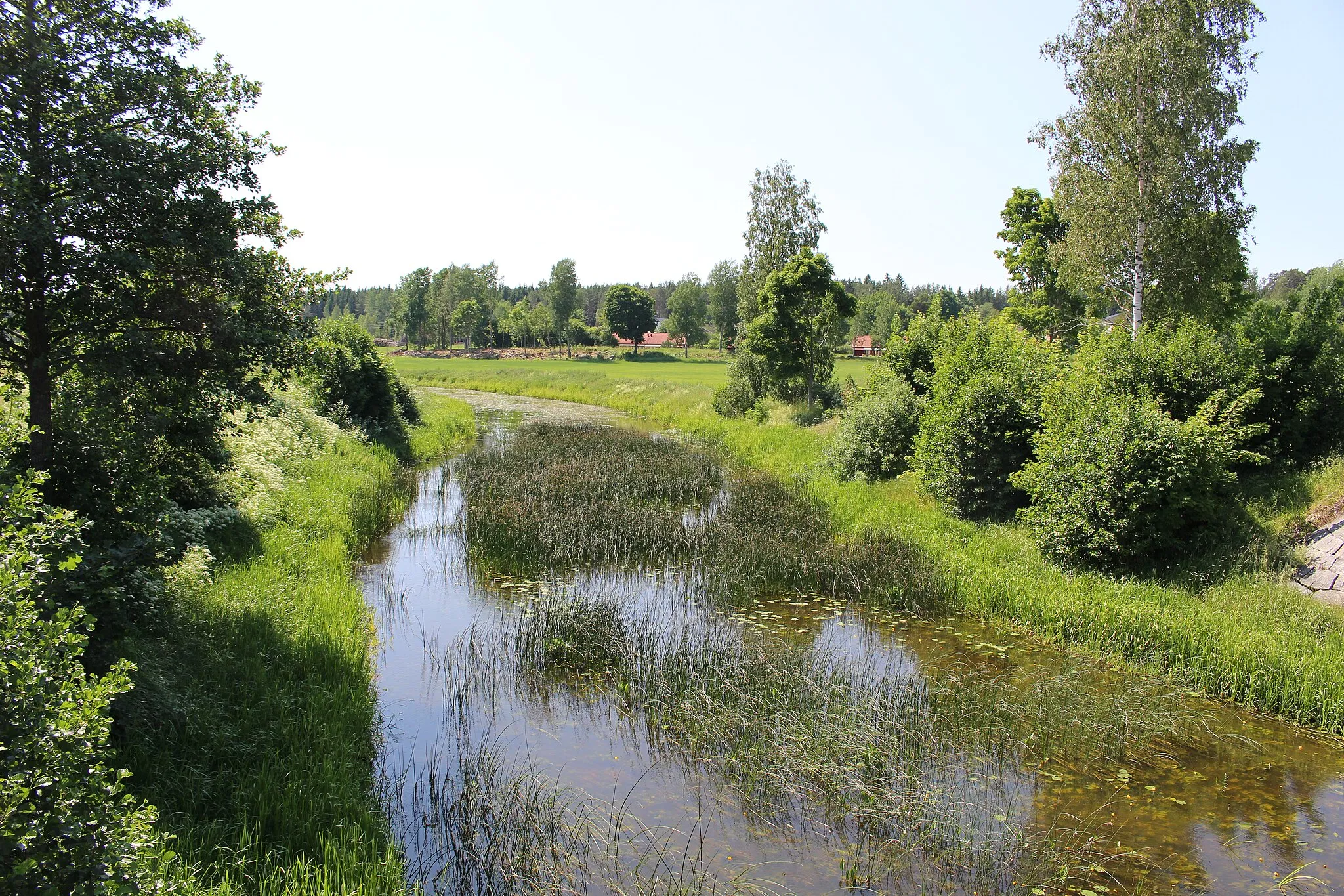 Photo showing: Olandsån mot söder från bron med Länsväg 288. Hökhuvuds kyrka i närheten.