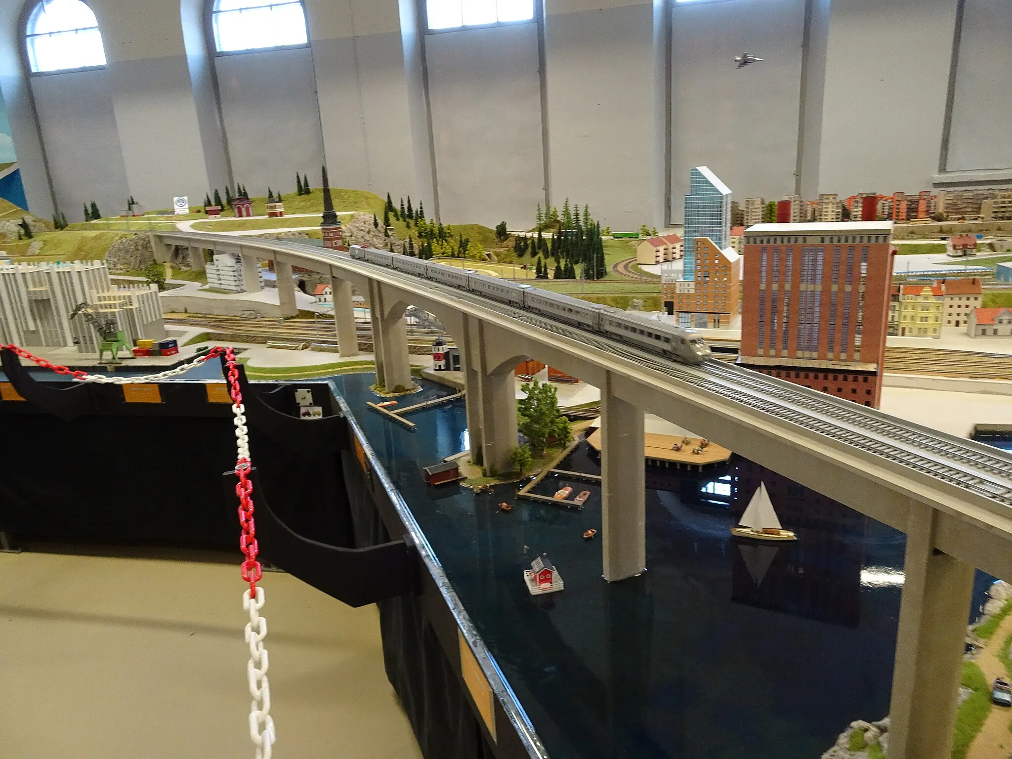 Photo showing: Miniature Kingdom, a model railway with miniature buildings depicting Sweden, located in Kungsör. This part describes Västerås with the combined heat and power plant, the cathedral, the skyscraper “Skrapan”, and Steam Hotel built in the closed old steam power plant. The Swedish high speed train X2000 is visible on the track.