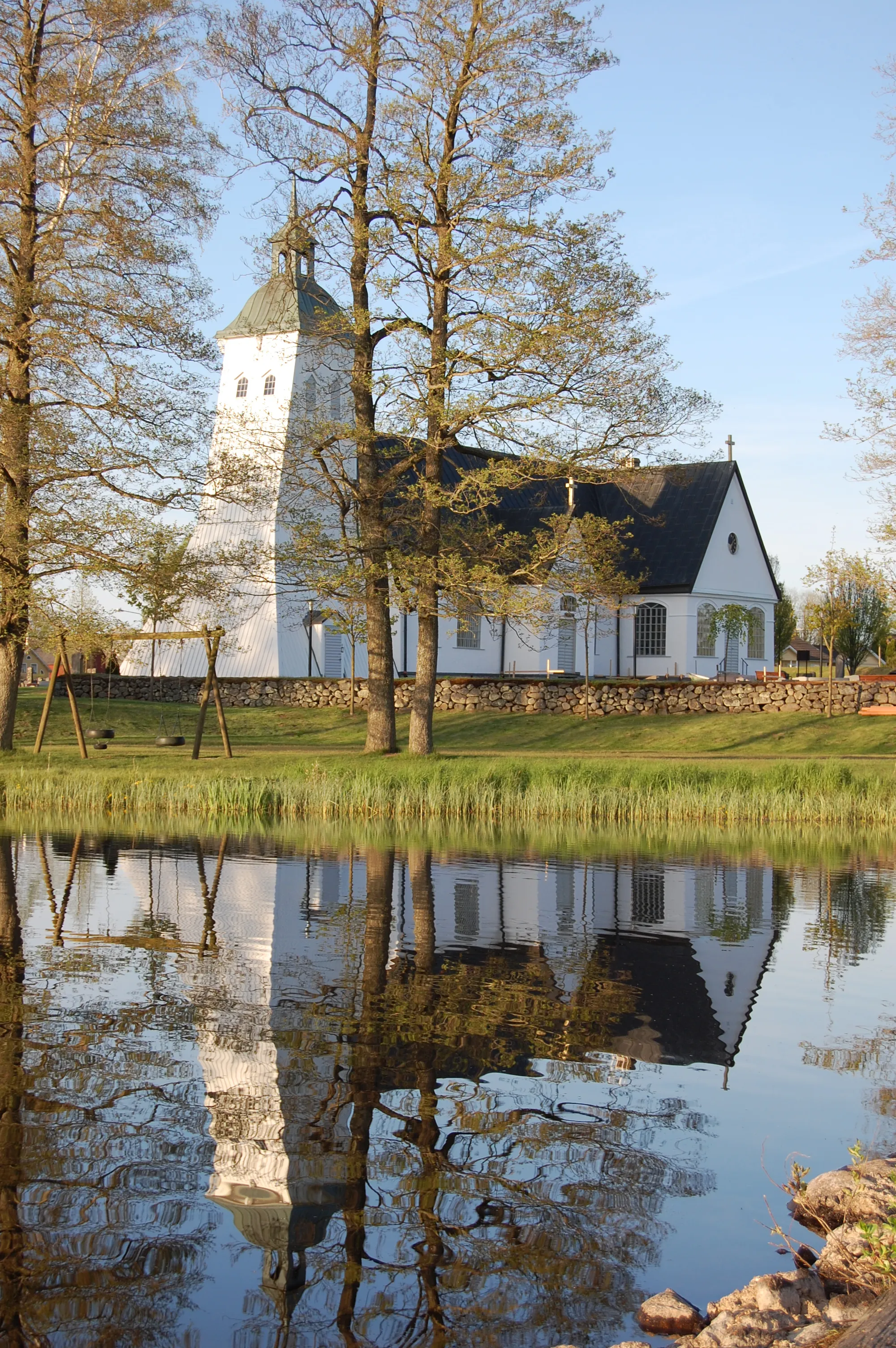 Photo showing: Tävelsås kyrka som sedd från badbryggan bakom skolan.