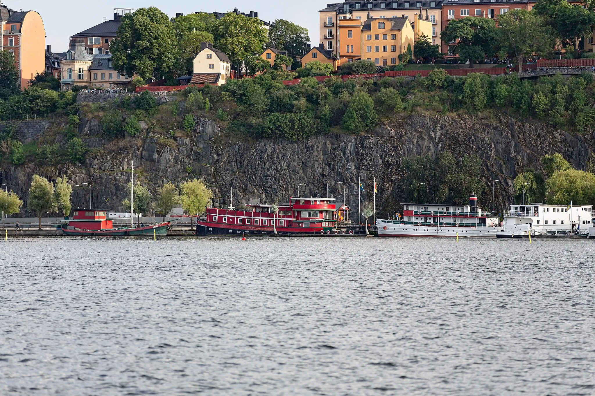 Photo showing: Mariaberget with Ivar Los park and the hotel boats Den Röda Båten, Ran af Stokcholm and Rygerfjord at Riddarfjärden (Södermalm, Stockholm, Sweden), seen from Stadshusparken.