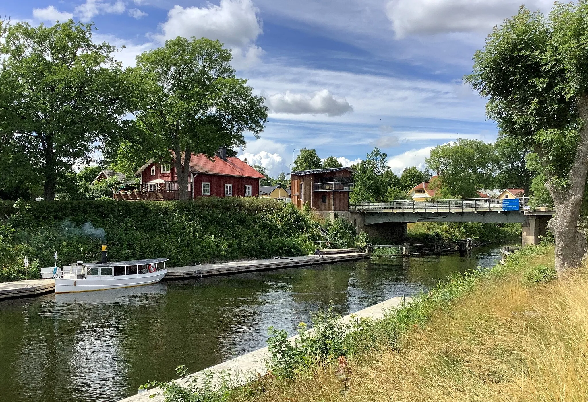 Photo showing: S/S Elmsta in Väddö canal in central Älmsta (or Elmsta) in Norrtälje Municipality, Stockholm County, Sweden. The ship belongs to the Maritime Museum of Roslagen. In the background Älmsta Bridge.