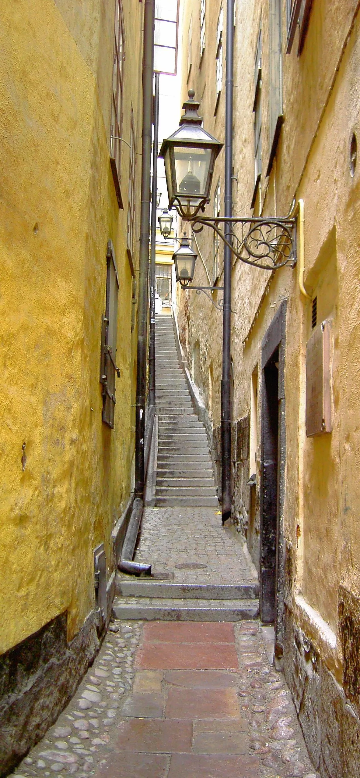 Photo showing: Mårten Trotzigs gränd (Swedish: "Alley of Mårten Trotzig") is the narrowest street in Stockholm, Sweden. It's situated in Gamla stan ("Old town"), the oldest part of the city. The actual age of the alley is unknown, but it was mentioned in 1544 as Tronge trappe grenden (in modern Swedish Trånga trappgränden, i.e. "Narrow Stairs Alley."). It's approximately 30 metres (98 ft) long and 90 centimetres (35 in) wide.