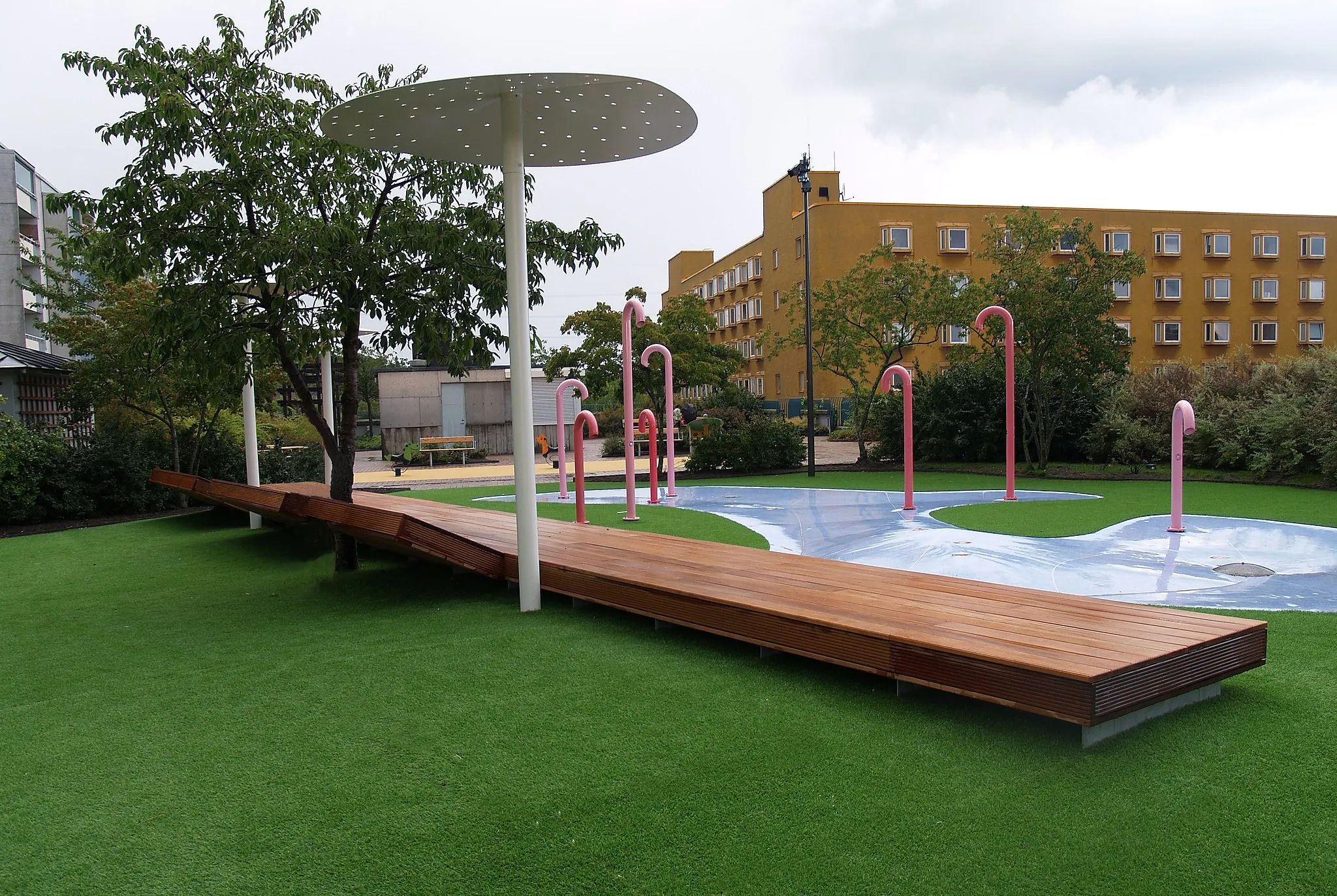 Photo showing: På Skärholmsterrassen ovanför torget hittar ni Flamingoparken, en vattenlek som under sommarhalvåret sprutar vatten då du som besökare trycker på olika knappar.