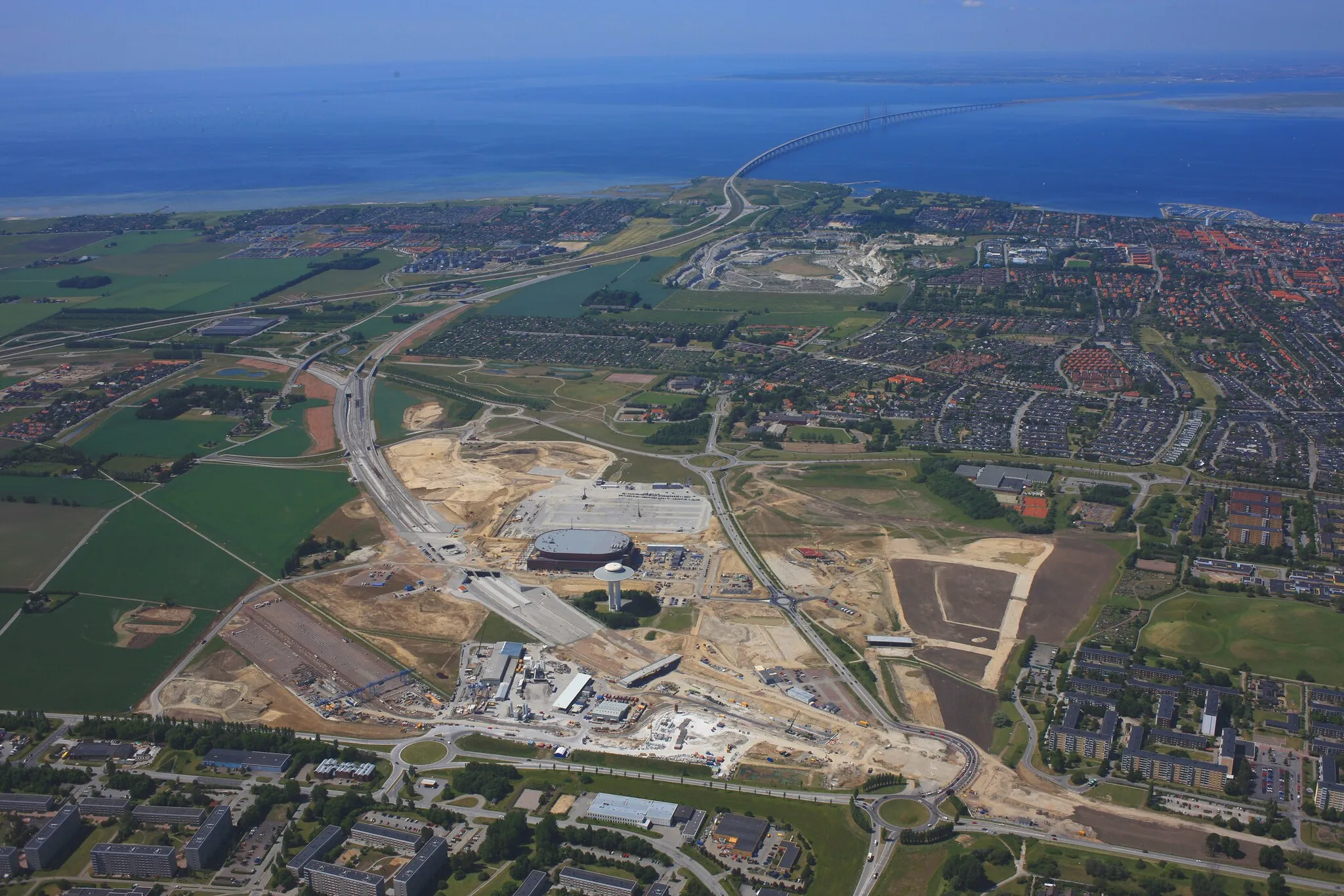 Photo showing: Citytunnelns arbetsområde vid Holma och Hyllie. Tunnelportalen och blivande station Hyllie. Öresundsbron i bakgrunden.