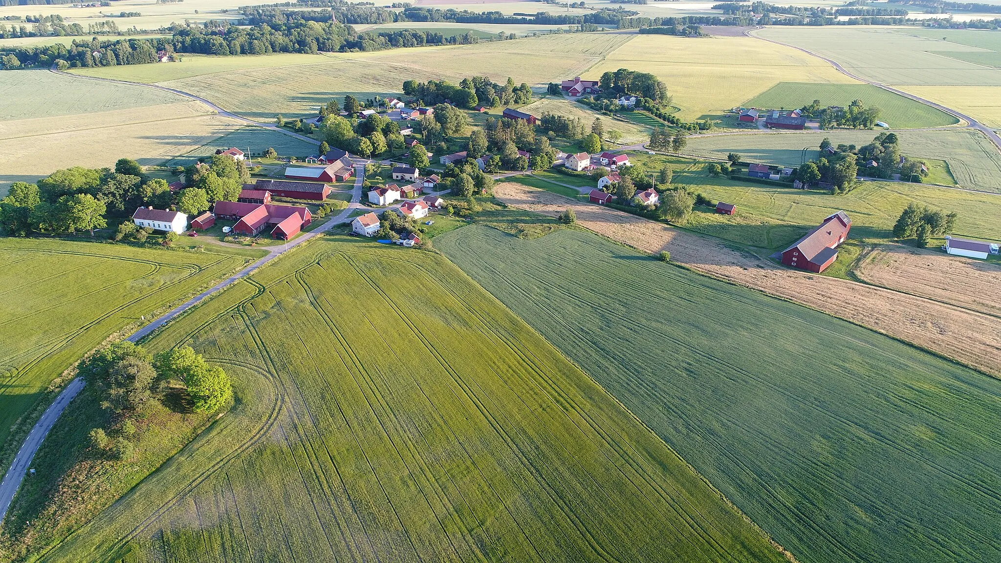 Photo showing: Norra Vånga village in Västergötland, Sweden, with Lumbers' tumulus in the foreground and the church in the background.