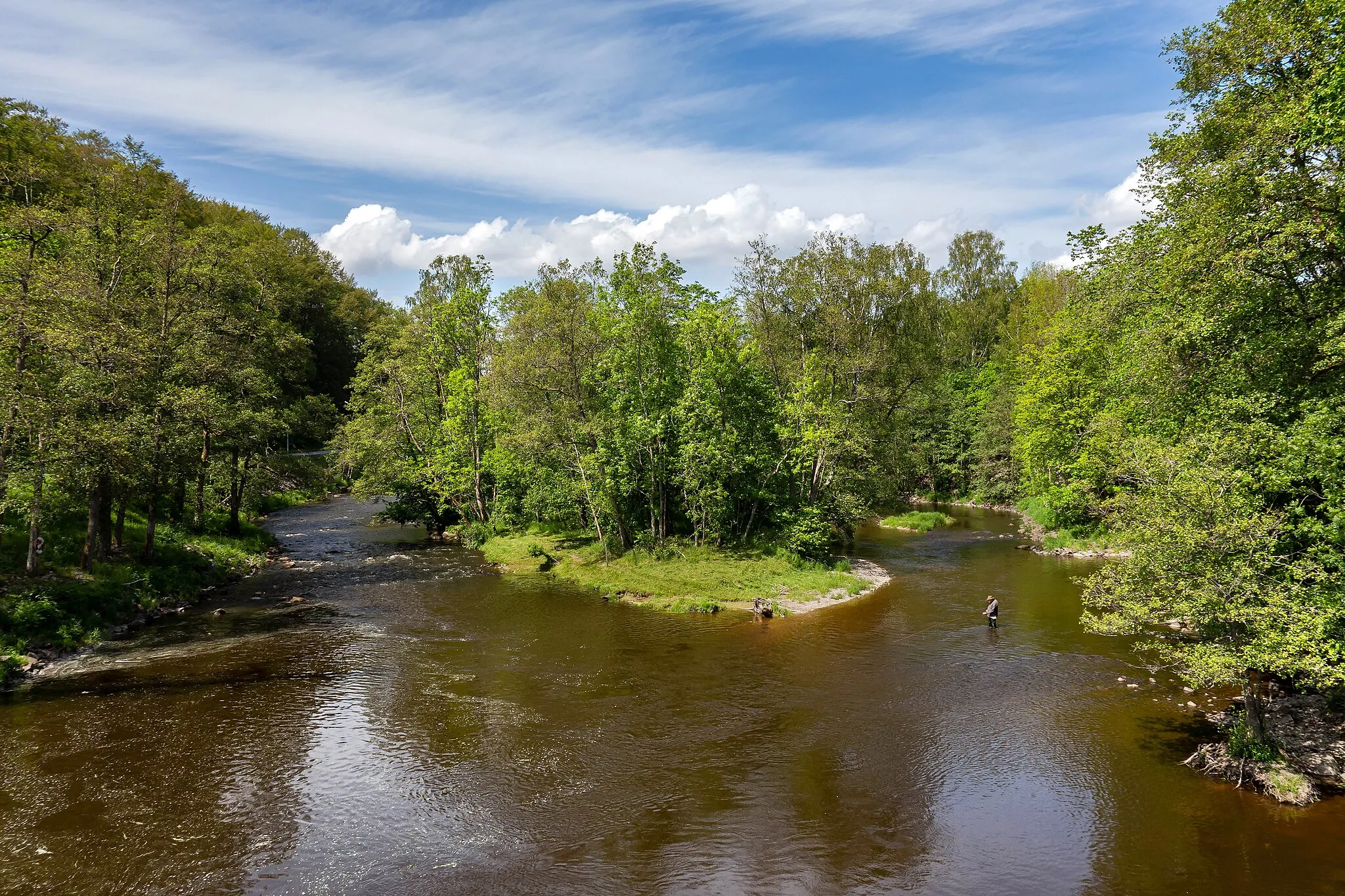 Photo showing: A man fishing in Örekilsälven upstream from Kvistrum bridge in Kviström, Munkedal Municipality, Sweden. Örekilsälven is a good place för salmon fishing.