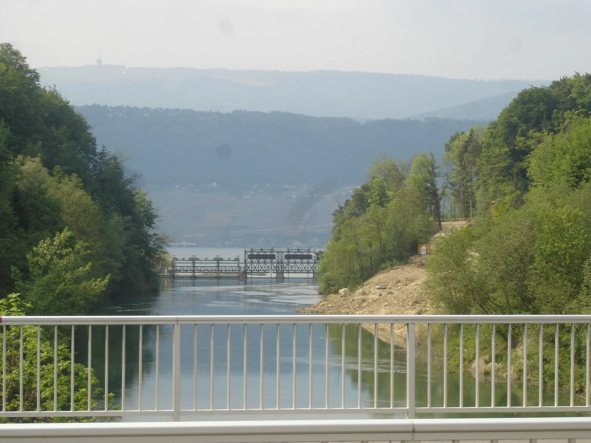Photo showing: Mündung des Hagneckkanals in den Bielersee bei Hagneck. Im Hintergrund ist das Stauwehr Hagneck zu sehen. Auf der rechten Seite wird der Kanal nach einem Hangrutsch im Frühling 2006 wieder auf sein ursprüngliches Profil ausgebaggert.