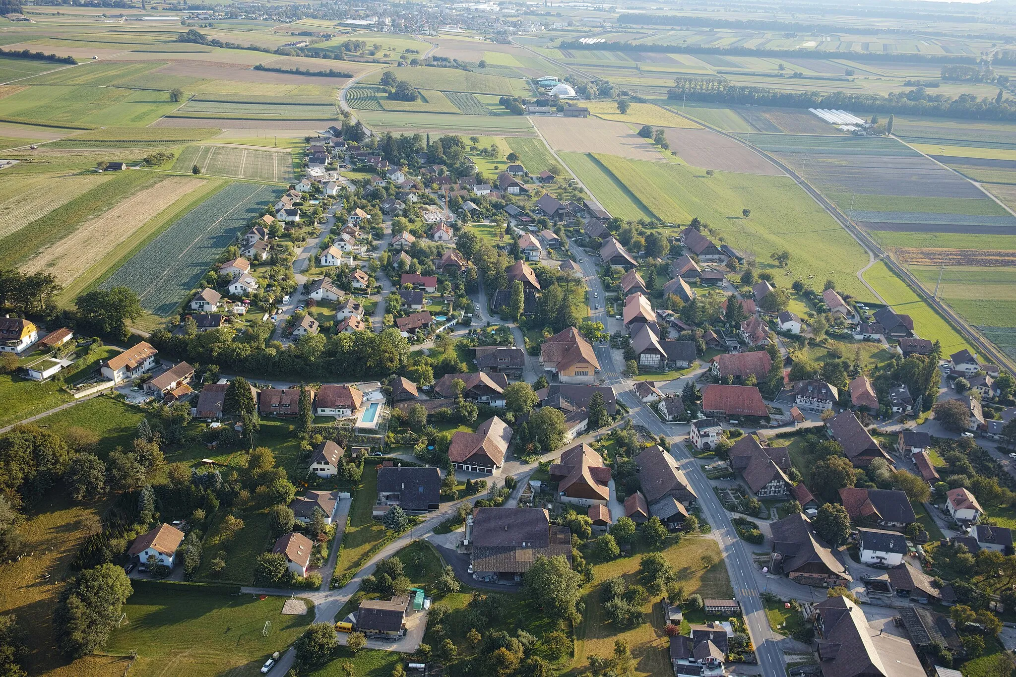 Photo showing: Municipality of Fräschels, canton of Fribourg, Switzerland. Picture taken from a hot air balloon. The Papiliorama (butterfly zoo) in the municipality of Kerzers is visible at the top of the image.