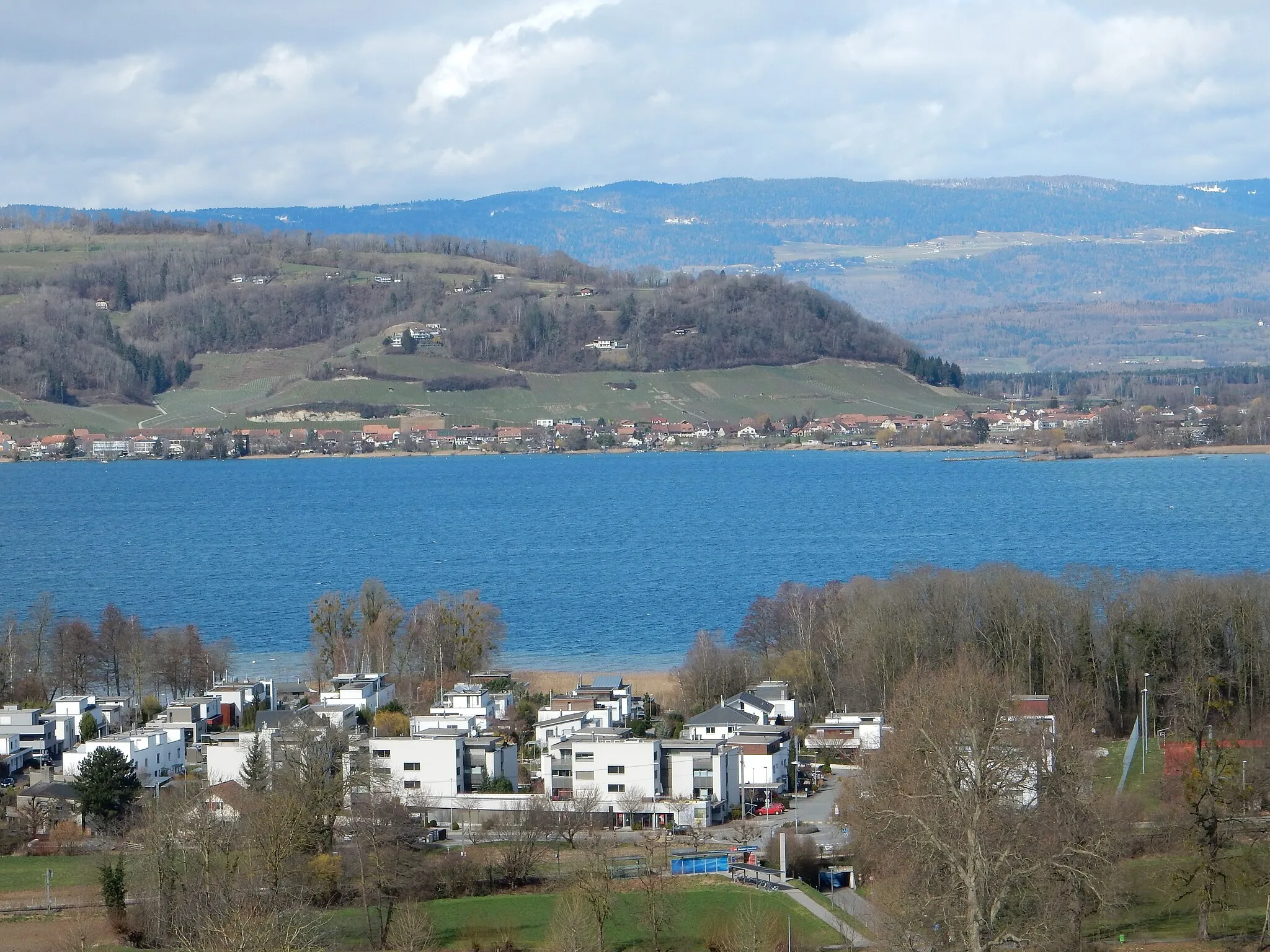 Photo showing: Am Murtensee: im Vordergrund Muntelier, am hinteren Ufer Sugiez und der Mont Vully, im Hintergrund der Jura