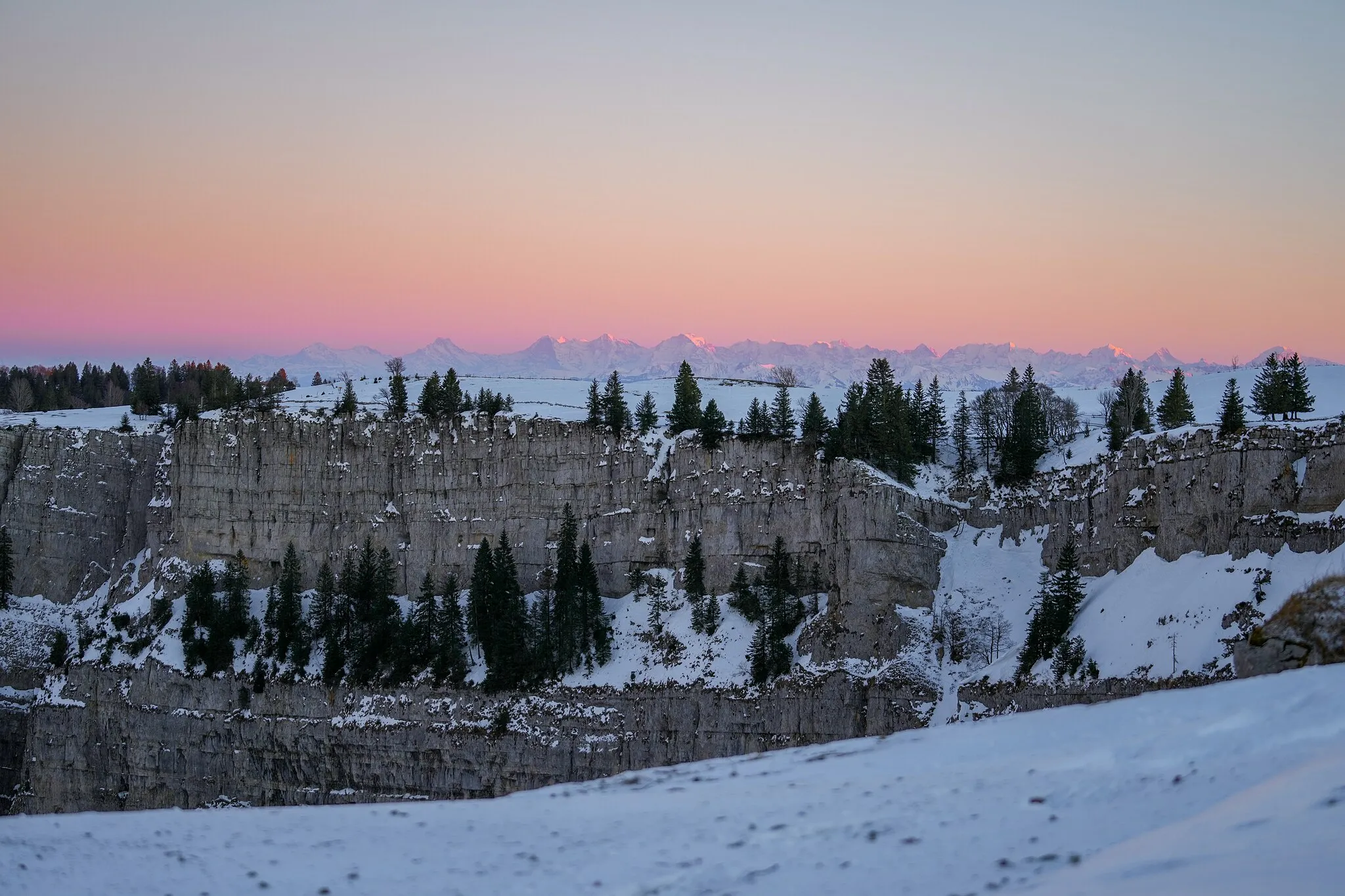 Photo showing: Creux du Van and Swiss Alps with snow at sunset