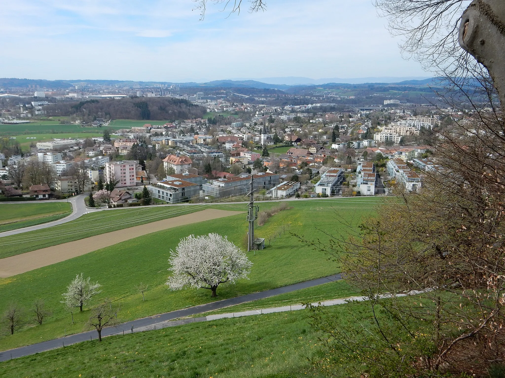 Photo showing: Bolligen (Kanton Bern, Schweiz): Übersicht der Ortschaft mit Kirche in der Mitte, im Hintergrund links die Stadt Bern