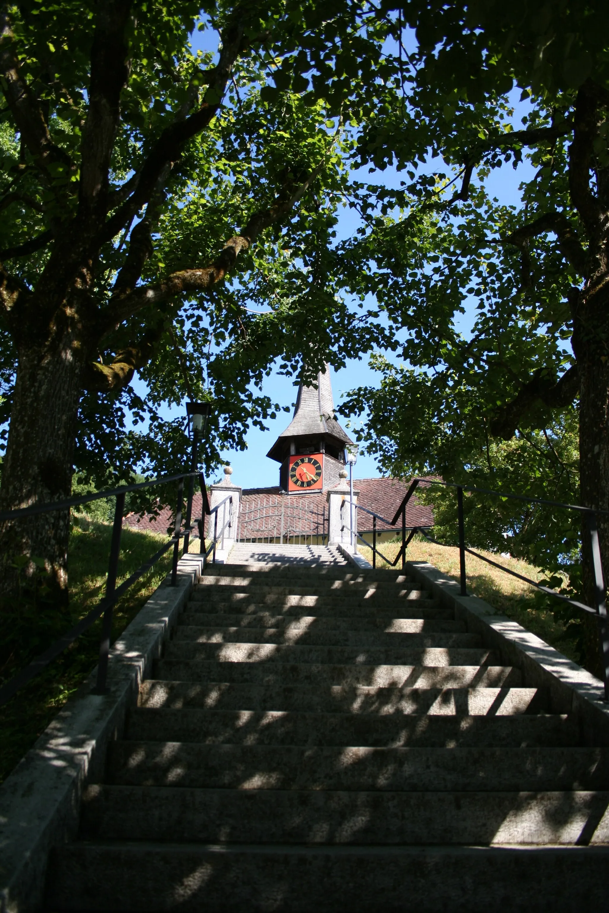 Photo showing: Die reformierte Kirche in Arch, Schweiz, besitzt vorne eine lange Treppe, welche mit einer Allee versehen ist.