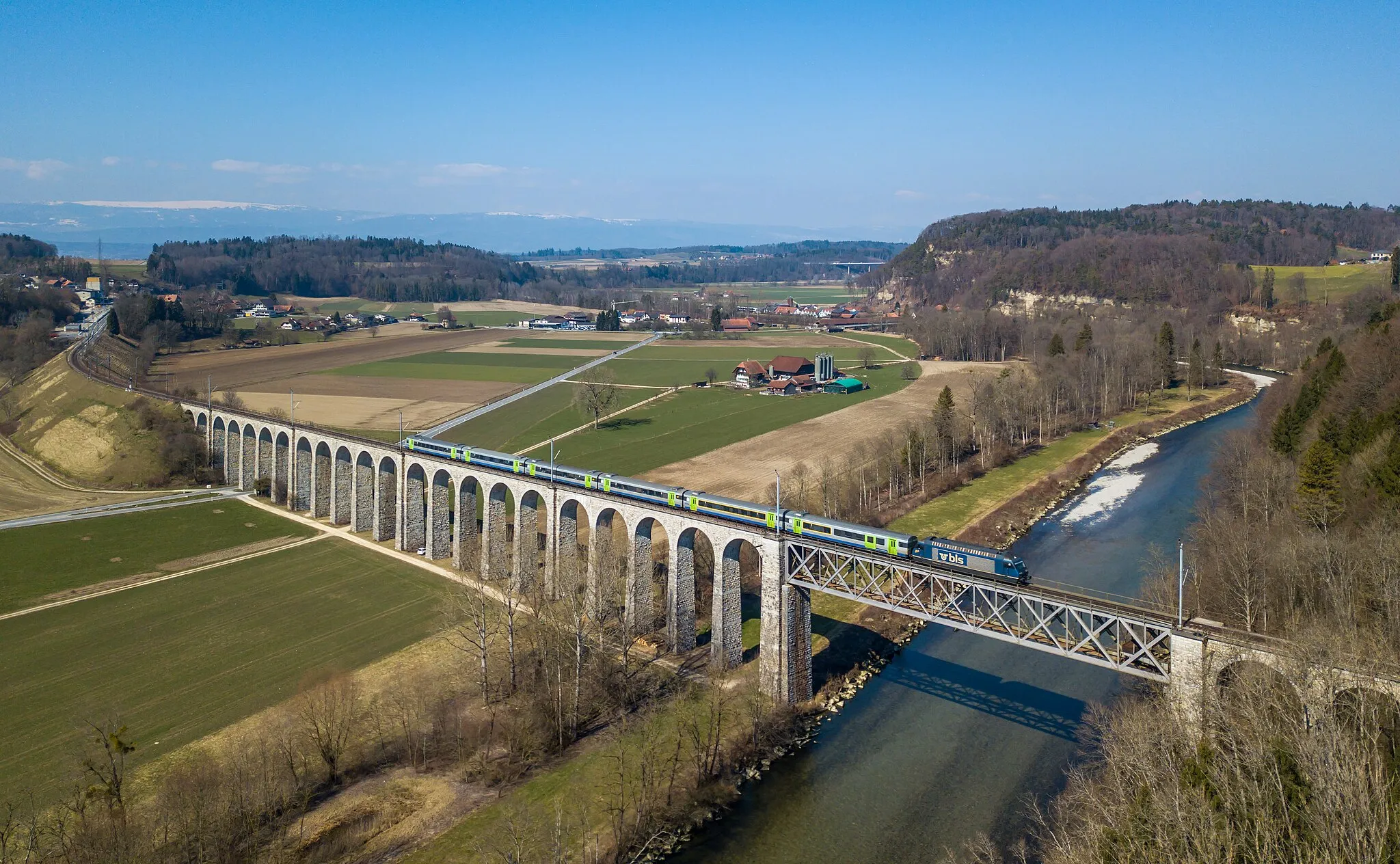 Photo showing: A BLS Re 465 with a RegioExpress from La Chaux-de-Fonds to Bern crosses the Saane viaduct near Gümmenen, Switzerland. Pictured with a drone (DJI Mavic Pro).