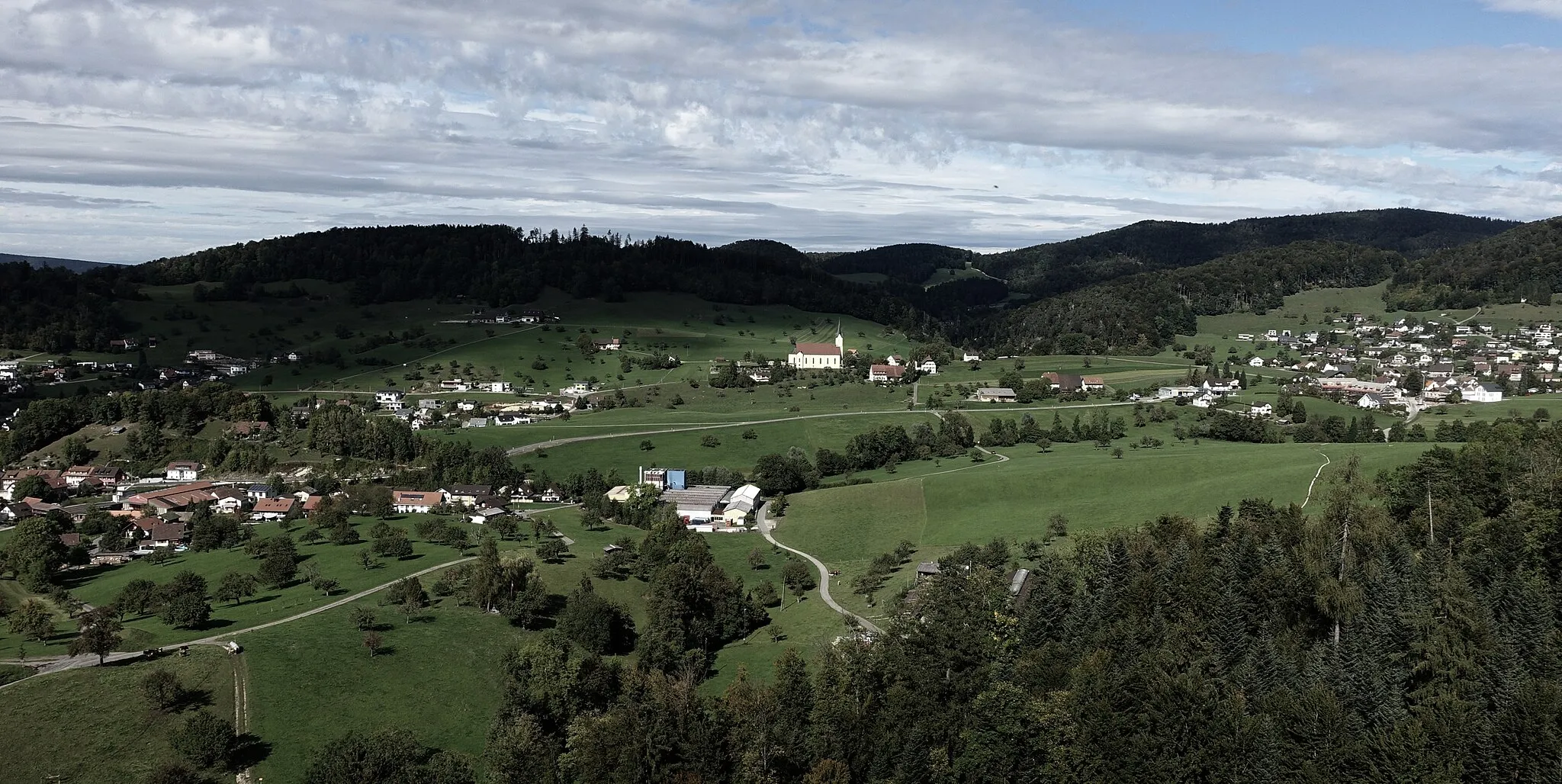 Photo showing: Blick von der Ruine Gilgenberg nach Zullwil, Pfarrkirche auf dem Weiler Oberkirch, Nunningen, Solothurner Faltenjuras, Schweiz