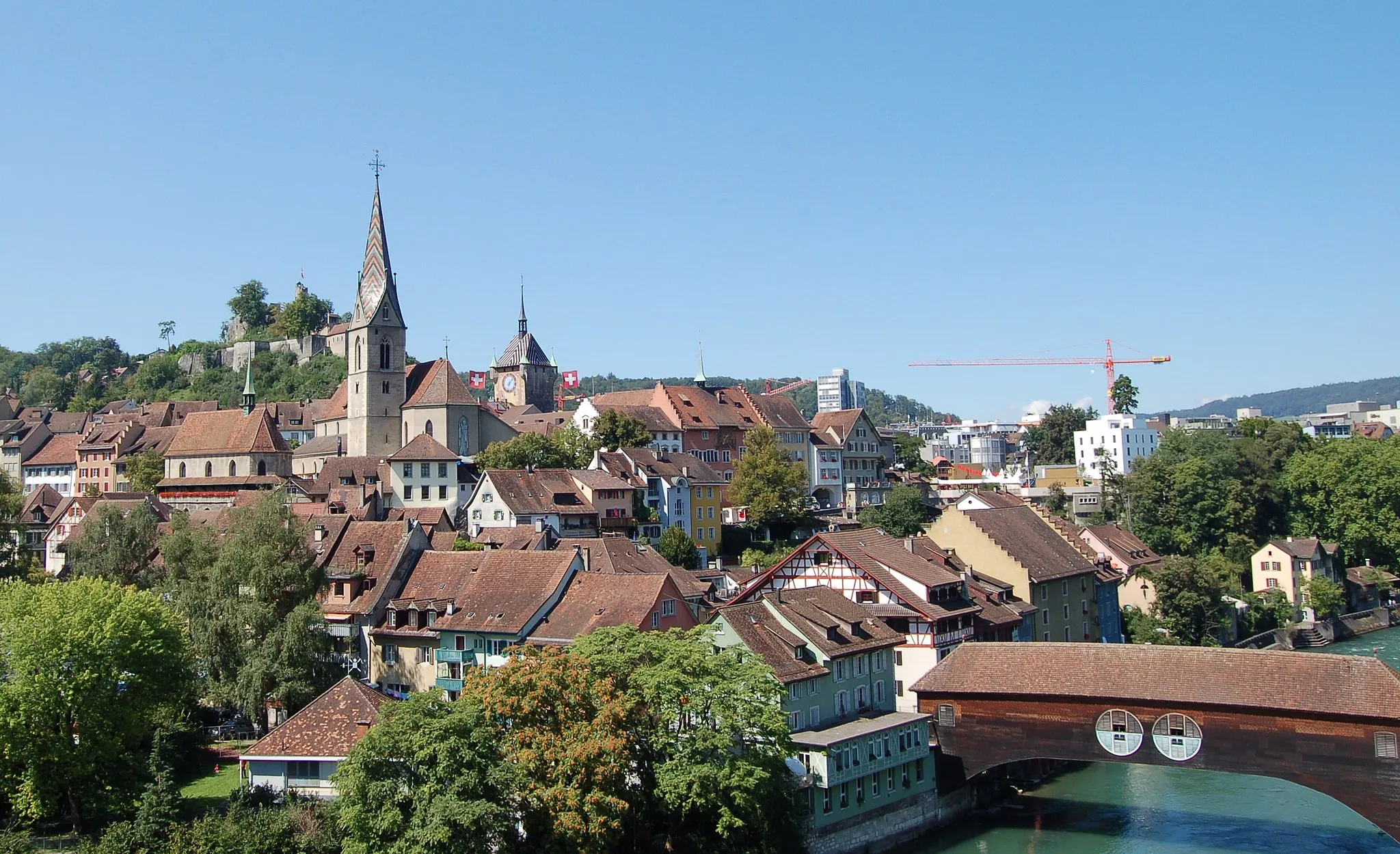 Photo showing: Baden, Switzerland. Old town view. Taken from Hochbrücke. Wooden bridge with a roof, church, town hall, ruins of castle.