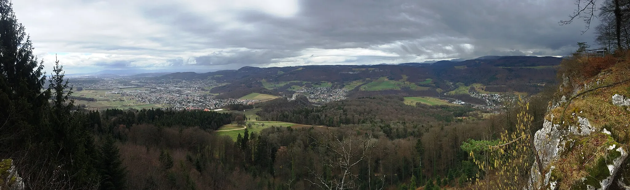 Photo showing: Blick von der Eggfluh in Richtung Grellingen (direkt vorne), Dornach und Arlesheim (etwas weiter links) und, im Hintergrund erkennbar am Rocheturm, Basel