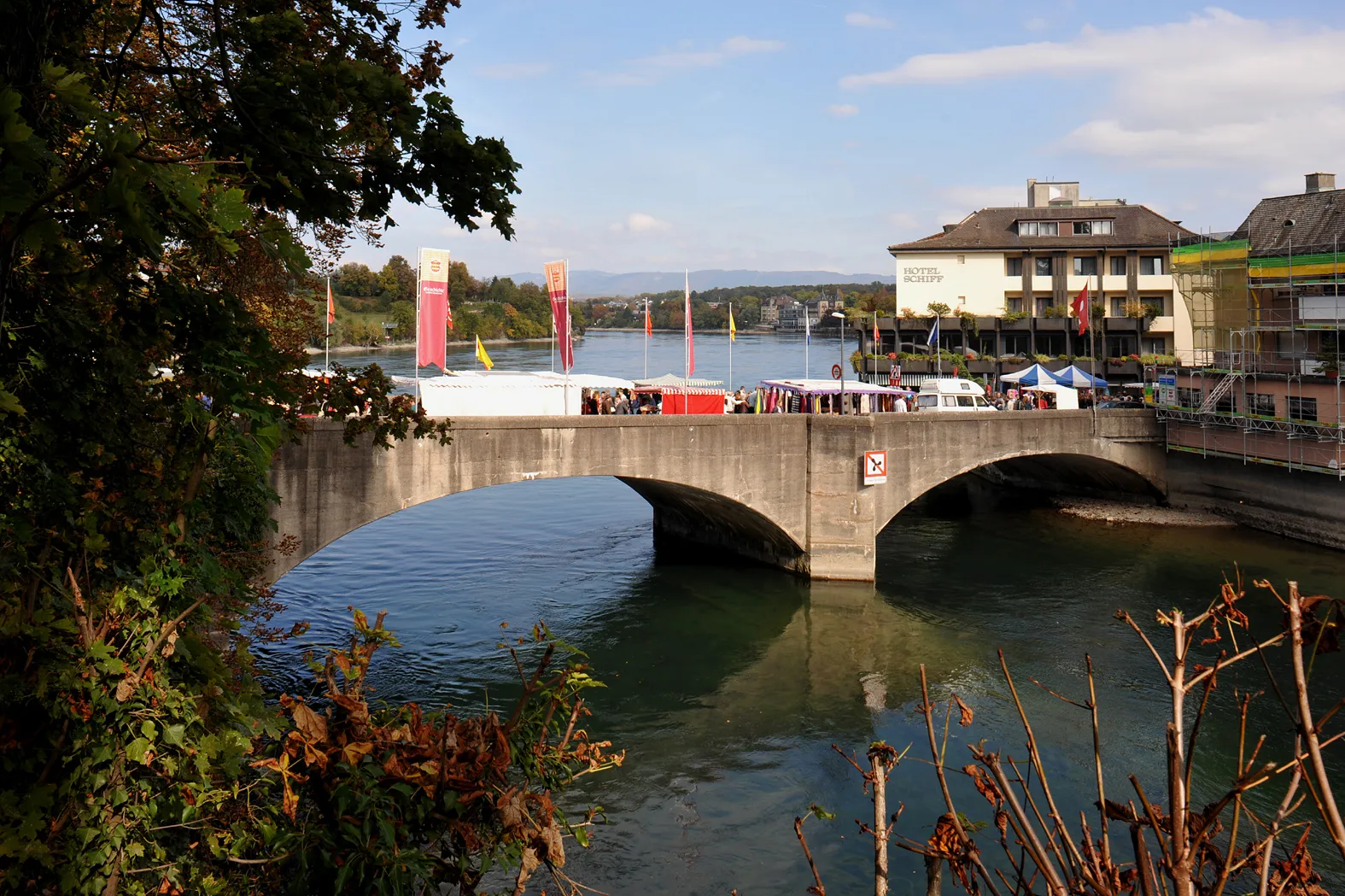 Photo showing: Old bridge over the Rhine by Robert Maillart in Rheinfelden, built 1912; Aargau, Switzerland and Baden-Württemberg, Germany.
Flags on the occasion of the Rheinfelden autumn market. Narrow part of the river on the Swiss side.