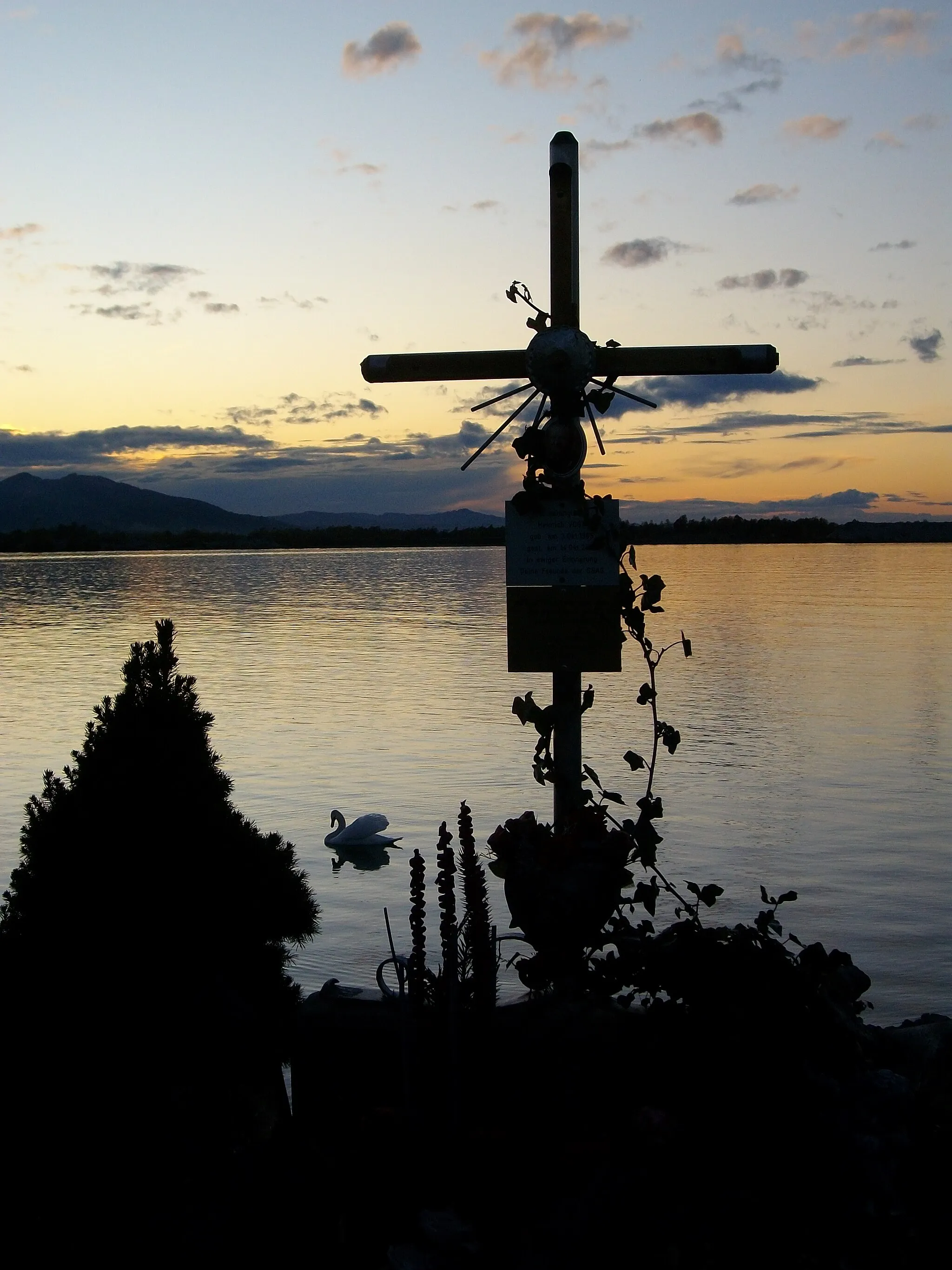 Photo showing: Das Grabkreuz ist ein christliches Gedenkzeichen für Grabstätten. Es soll die Verbindung des gekreuzigten und auferstandenen Christus mit der Hoffnung auf die Auferstehung der Toten symbolisieren. Im Bild ein Kreuz an der Harder Hafeneinfahrt mit Blick auf den Bodensee.