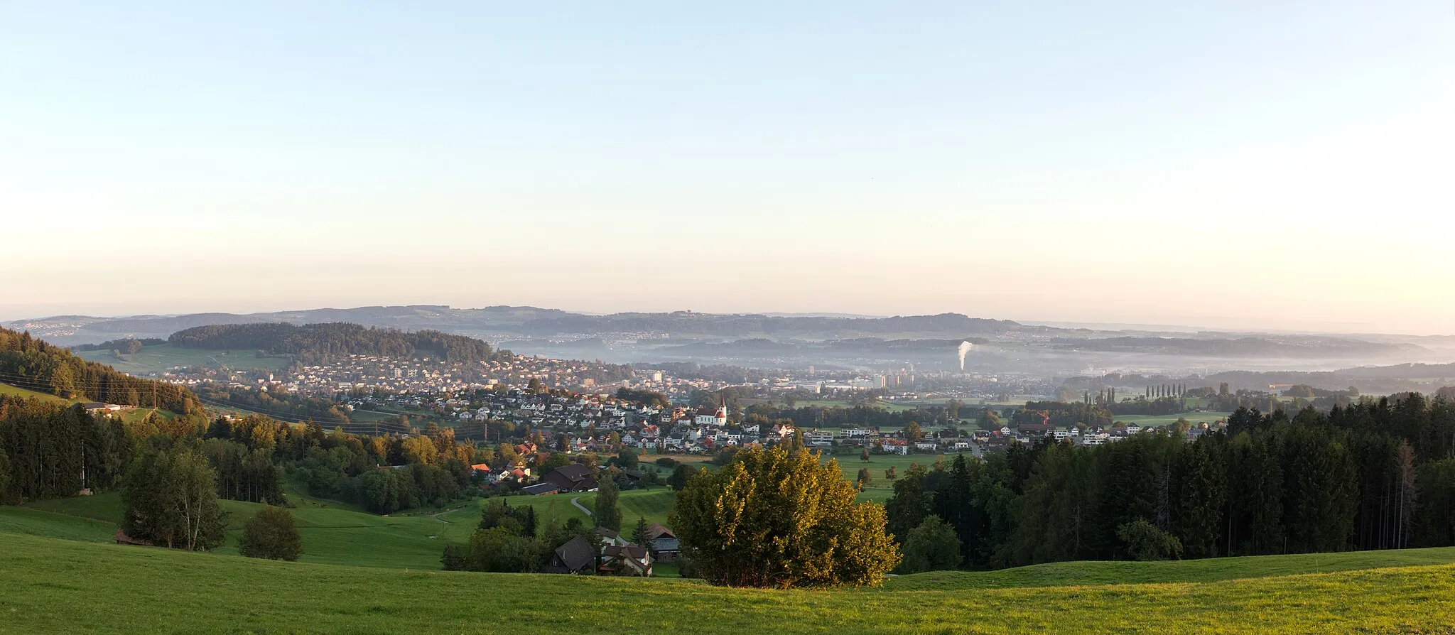 Photo showing: Panoramic view over Bichwil, Oberuzwil and Uzwil from the Eppenberg hill in the morning hours right at sunrise.