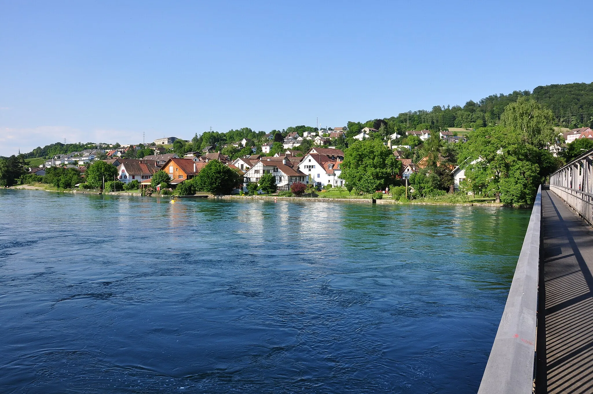 Photo showing: Flurlingen (Switzerland), as seen from Neuhausen am Rheinfall, Rhine in the foreground.