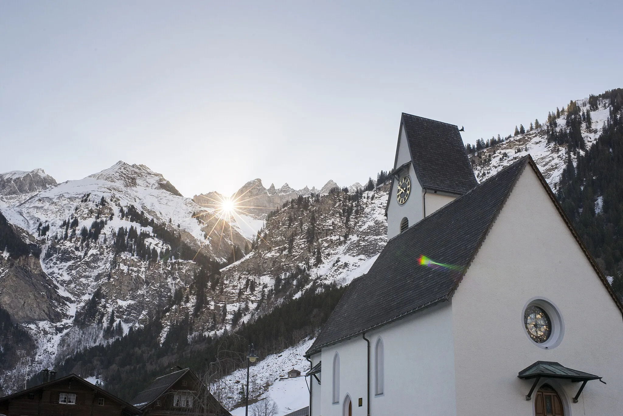 Photo showing: Die Sonne scheint durch das Martinsloch auf die Kirche von Elm in Glarus Süd, Kanton Glarus