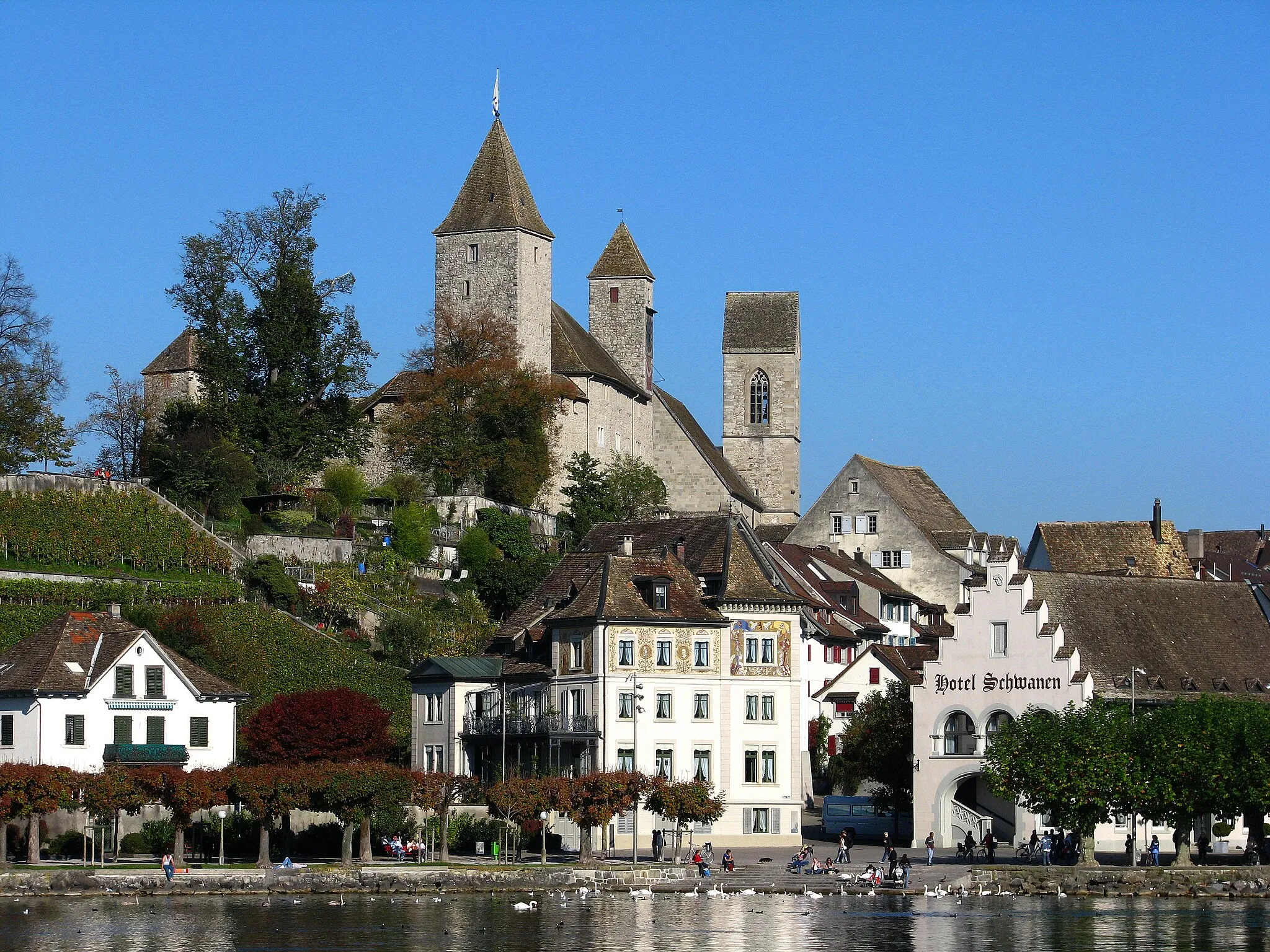 Photo showing: Rapperswil (SG) : Historical quarter, Schloss Rapperswil and St. John's church (tower to the right side), as seen from Zürichsee (Lake Zürich) harbour.