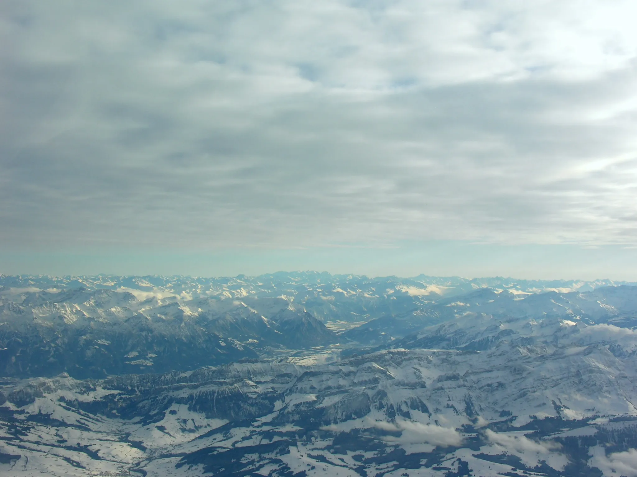 Photo showing: Blick über Appenzeller Land und Alpstein ins Rheintal (in der Bildmitte Triesen), im Hintergrund links das Rätikon, rechts die Glarner Alpen, am Horizont die Berninagruppe