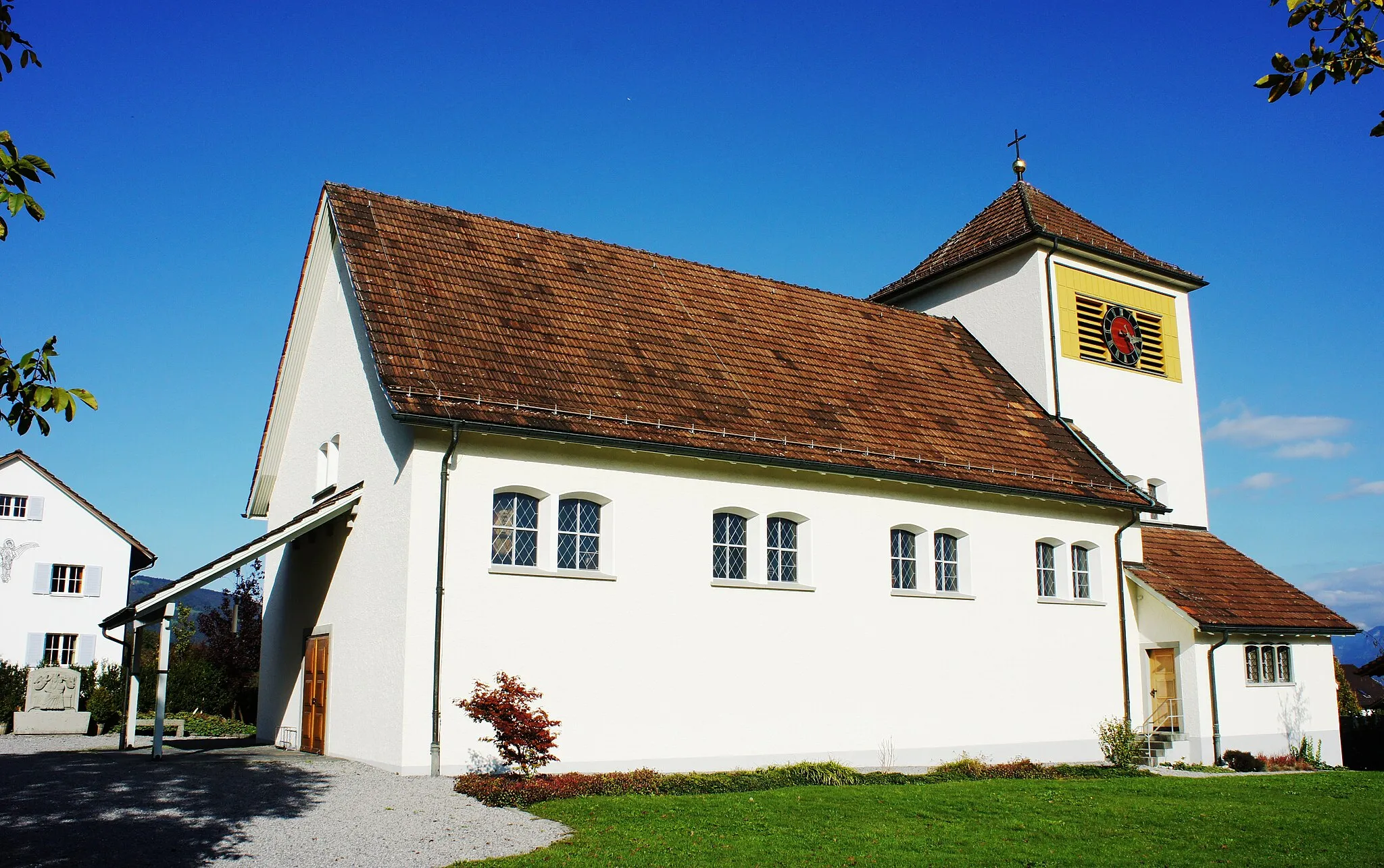 Photo showing: Die kath. Kirche Hinterforst (Gemeinde Altstätten SG) von Südwesten. Links neben dem überdachten Eingang an der Westfassade erkennt man das Pfarrhaus. Über dem Chorraum erhebt sich ca. 1 Meter über dem Dachfirst der gemauerte Teil des Kirchturms. An der Südostecke der Kirche ist die Sakristei mit Dreier-Fenster und eigenem Eingang angebaut. Im Innern sind Deckengemälde von Ferdinand Gehr.