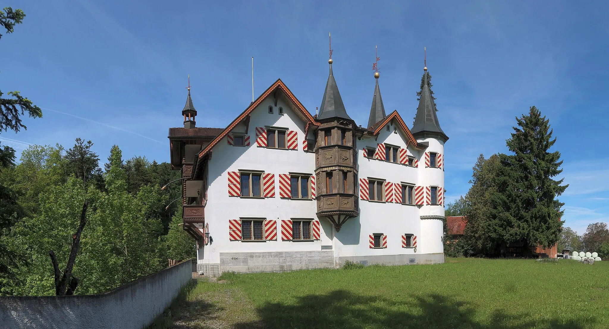 Photo showing: The east side of the castle. The building consists of two parallel gabled houses connected by a transverse structure. On the left there is a ravine with a brook.