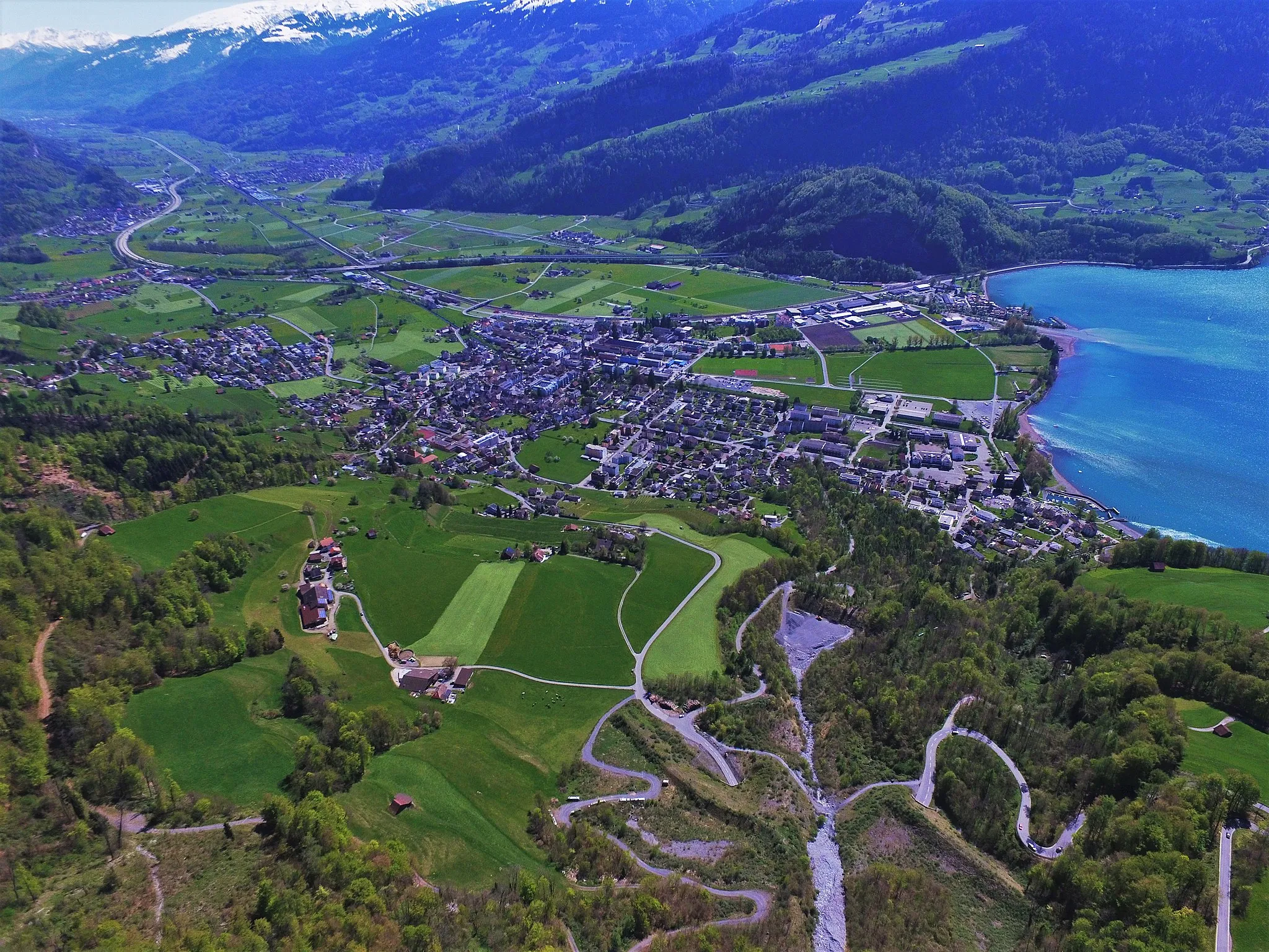 Photo showing: Walenstadt am Walensee im Vordergrund, links anschliessend Tscherlach und Berschis (links des Bogens der Autobahn A13). Etwas weiter entfernt Flums. Blickrichtung SSO von einer Drohne