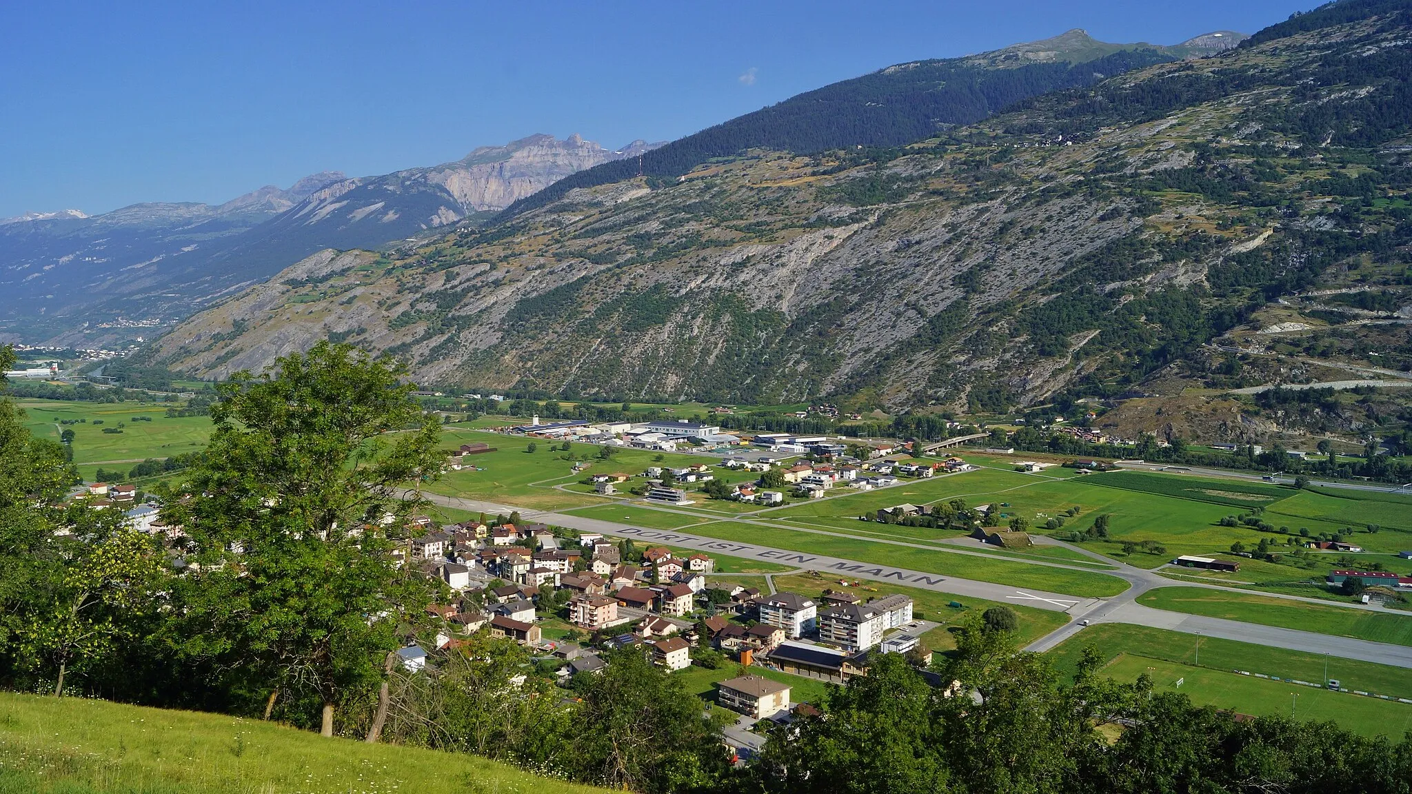 Photo showing: Blick von Ried auf Turtmann mit dem ehemaligen Militärflugplatz und in die Berner Alpen.