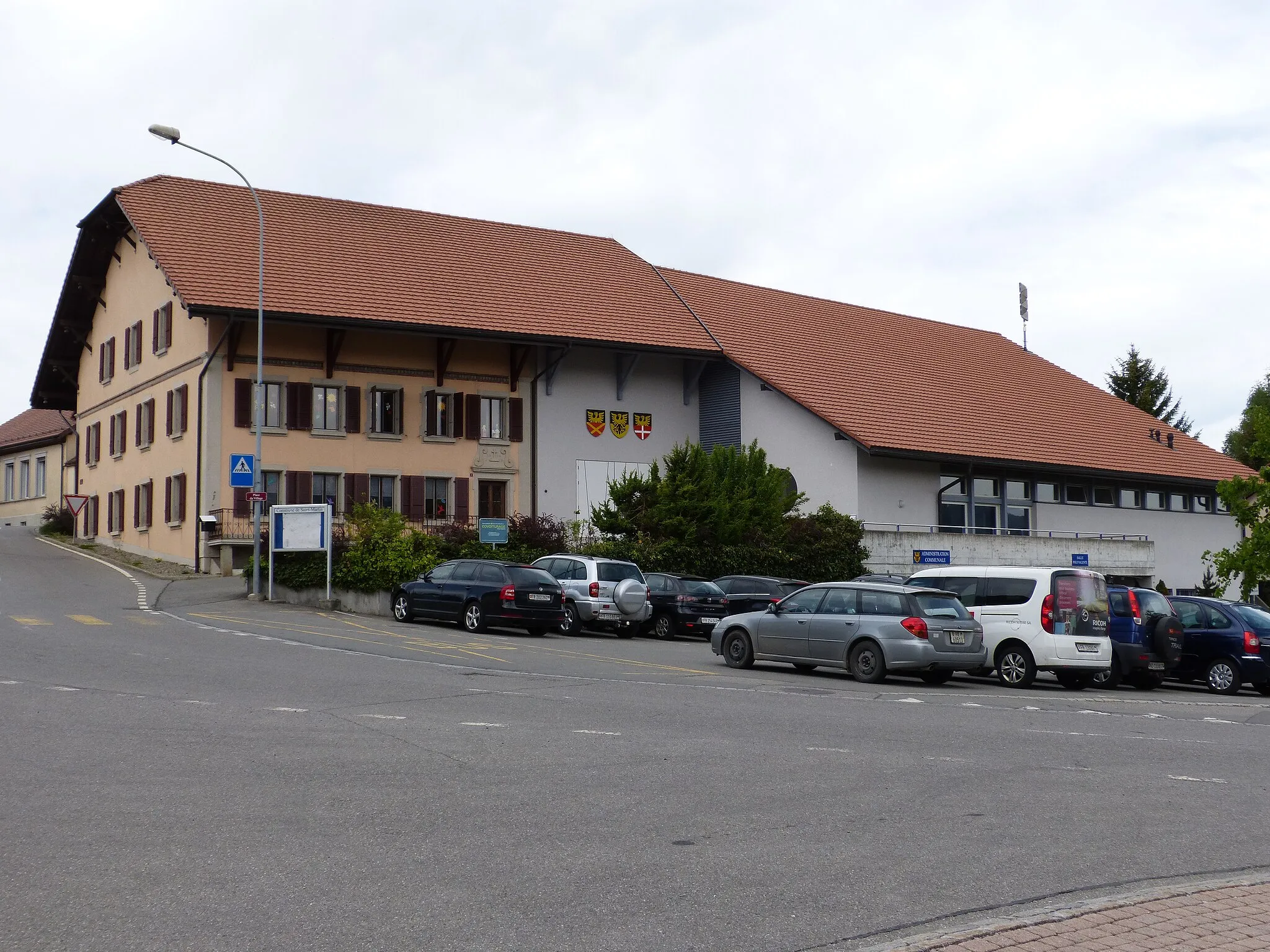 Photo showing: View of the town house of Saint-Martin with detailed coat of arms from the three localities forming the municipality : Besencens, Saint-Martin and Fiaugères.