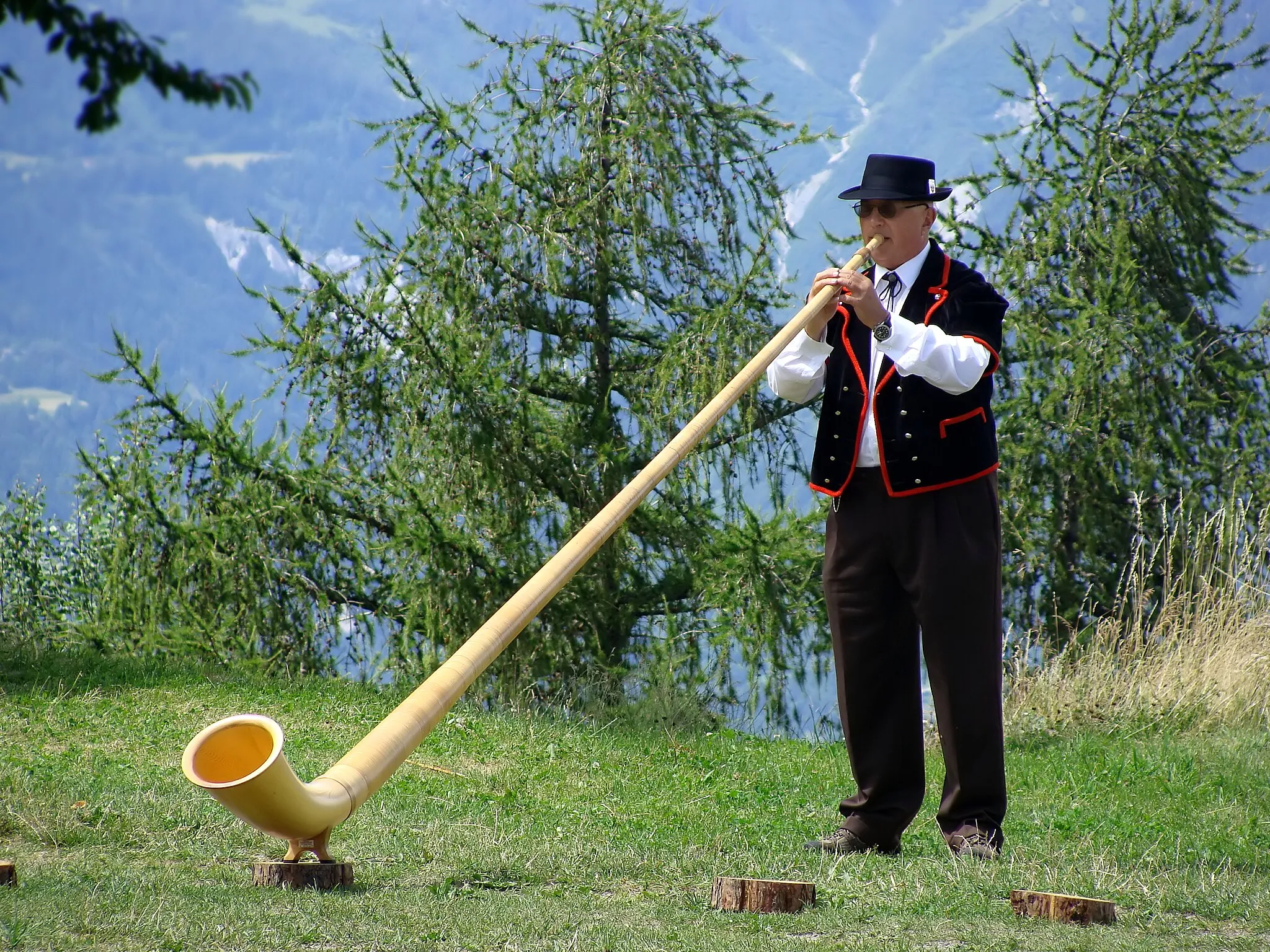 Photo showing: Alphorn player in Nendaz, Wallis, Switzerland.