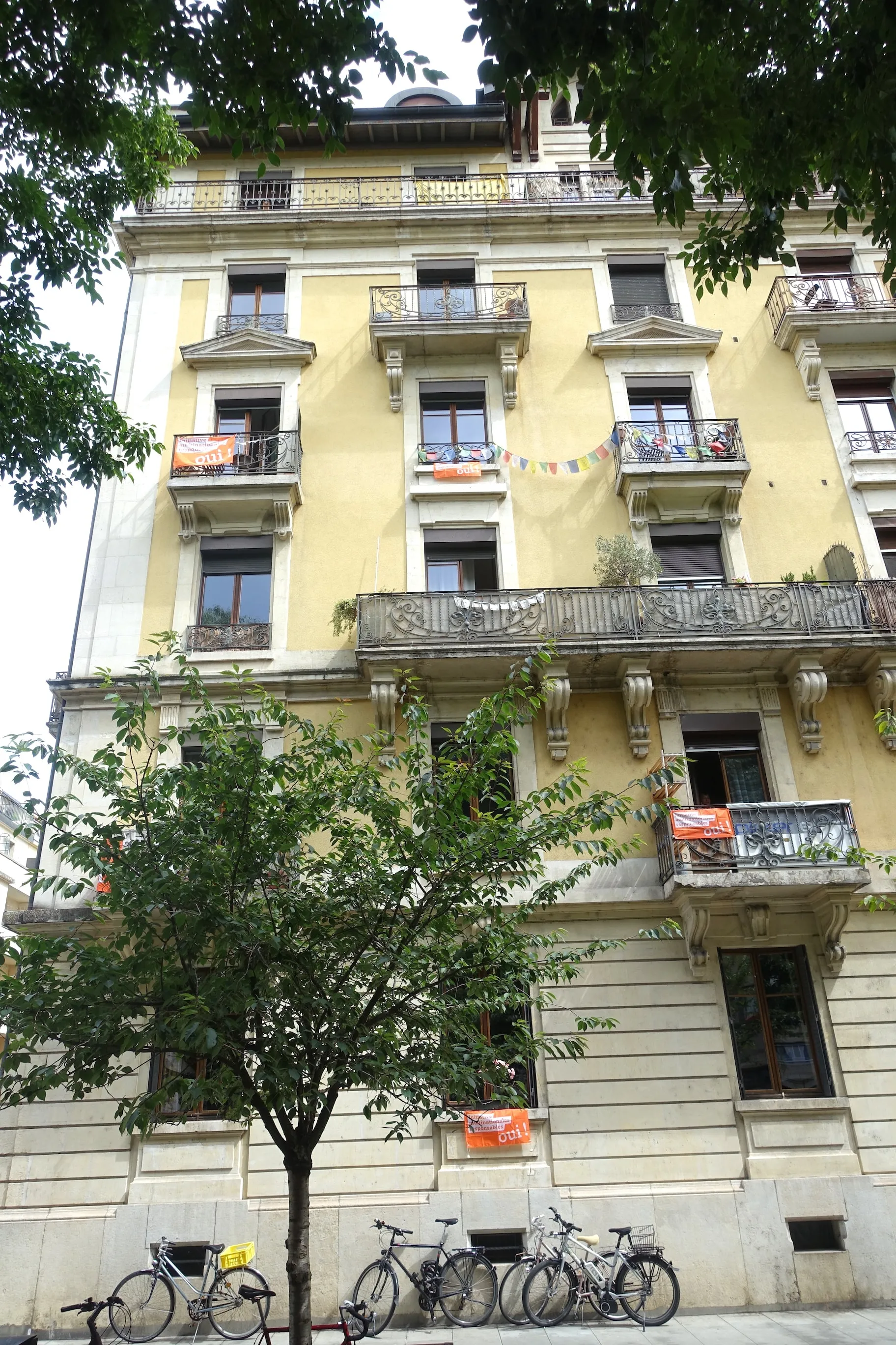 Photo showing: Bâtiment au 2 rue Jean-Jaquet et une façade au 10 rue du Léman, dans le quartier des Pâquis à Genève. Il porte une vingtaine de banderoles en soutien à l'initiative populaire « Entreprises responsables – pour protéger l’être humain et l’environnement ».