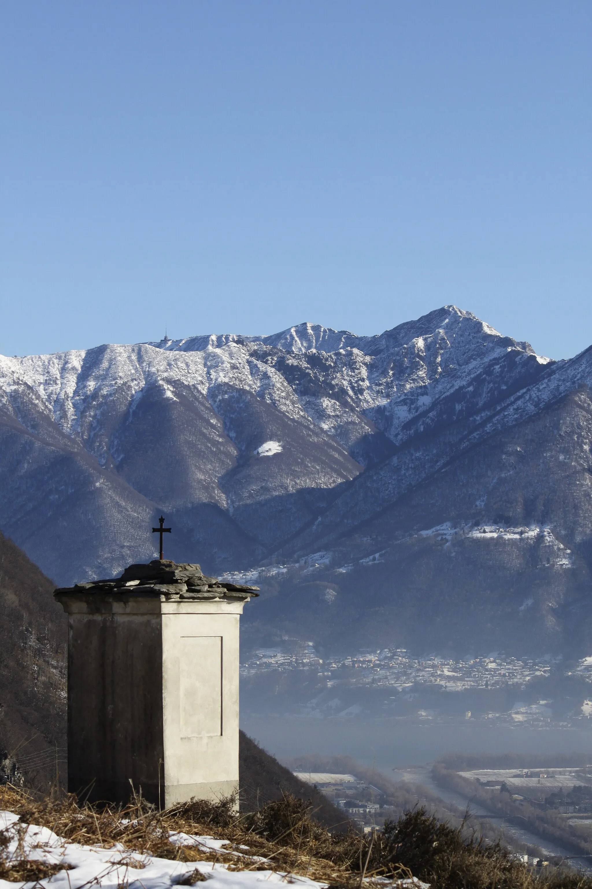 Photo showing: Chapel at Comoi, Tegna. In the background Lake Maggiore, Monte Tamaro and the Lugano Prealps.